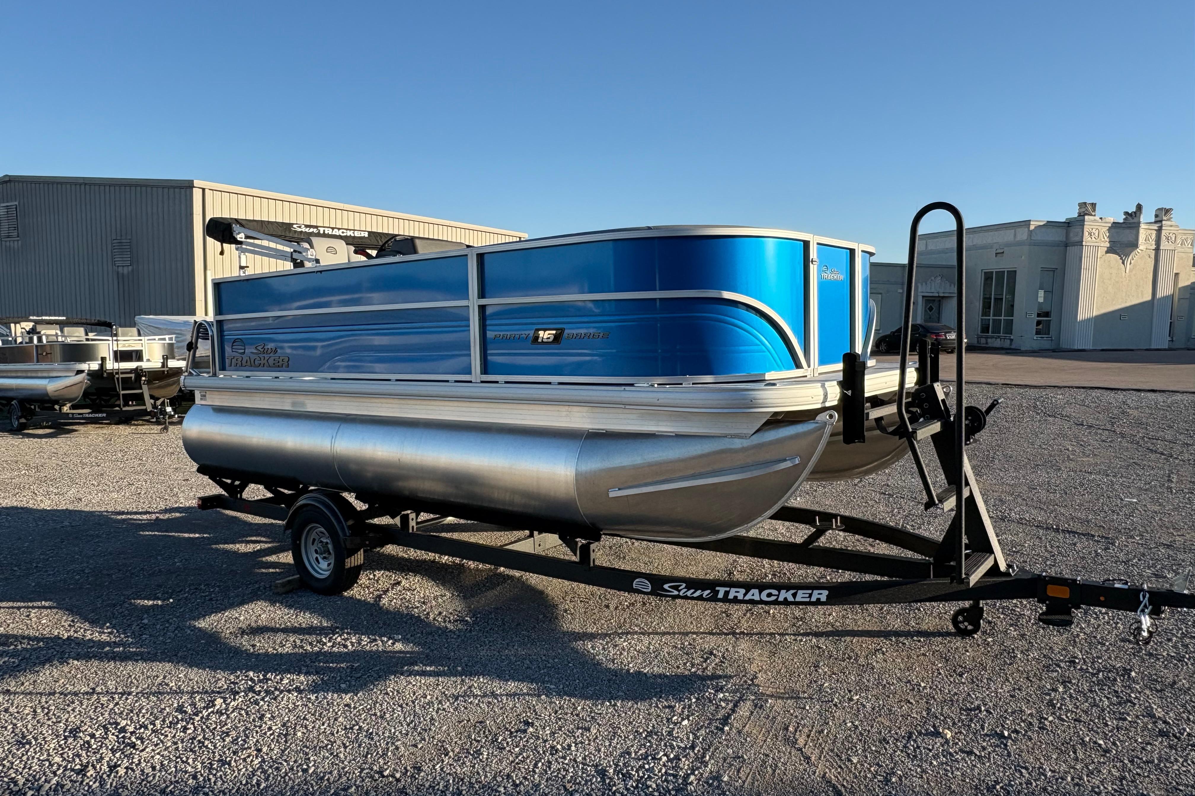 2026 Sun Tracker Party Barge 16 DLX pontoon boat on trailer in outdoor setting.
