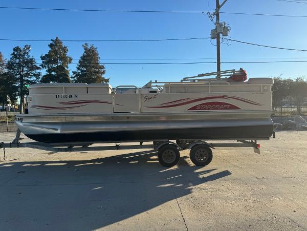 2005 Starcraft 22 Sport pontoon boat on trailer, parked outdoors.