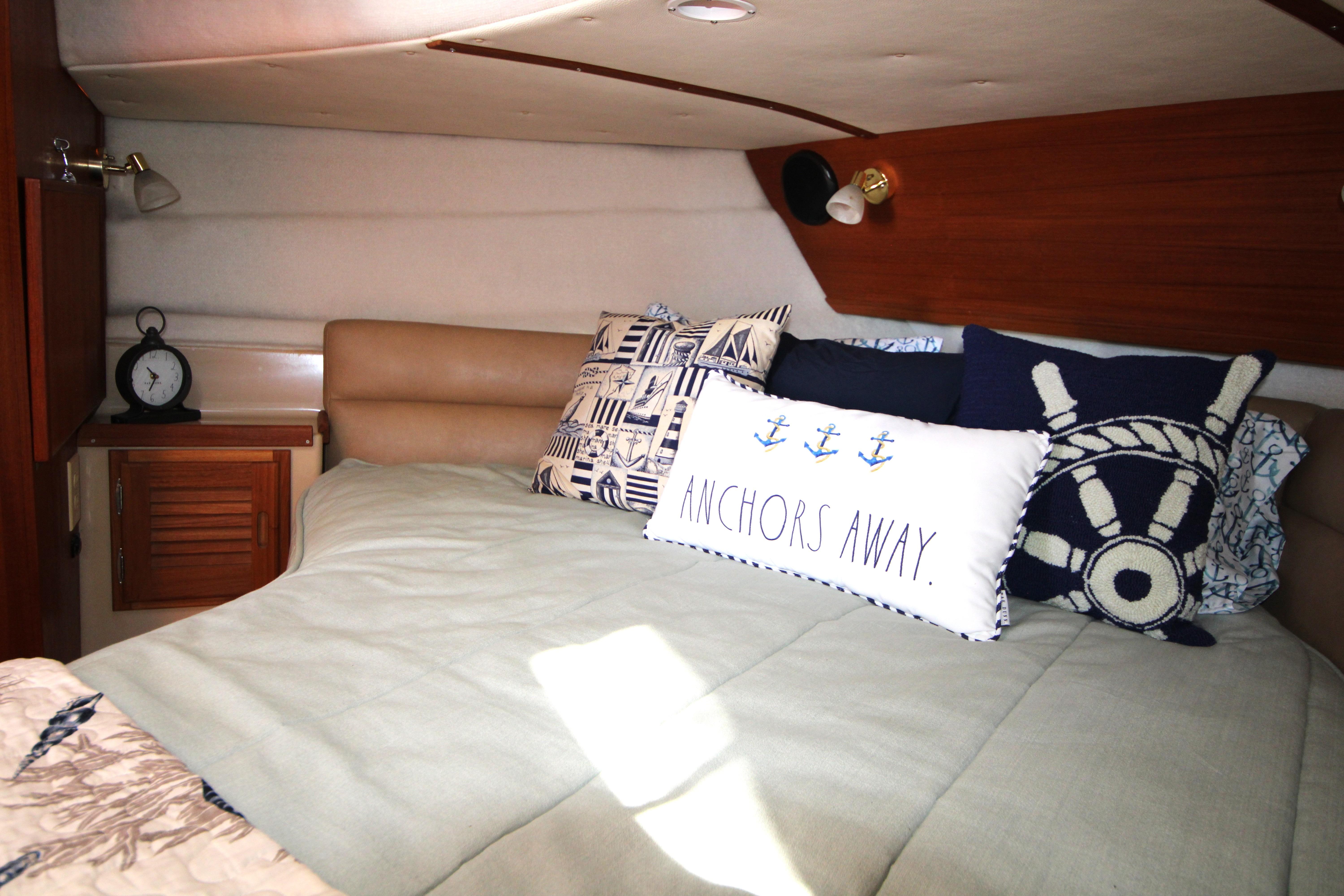 Cozy cabin interior of 2013 Ranger Tugs R-31 CB with nautical-themed pillows.