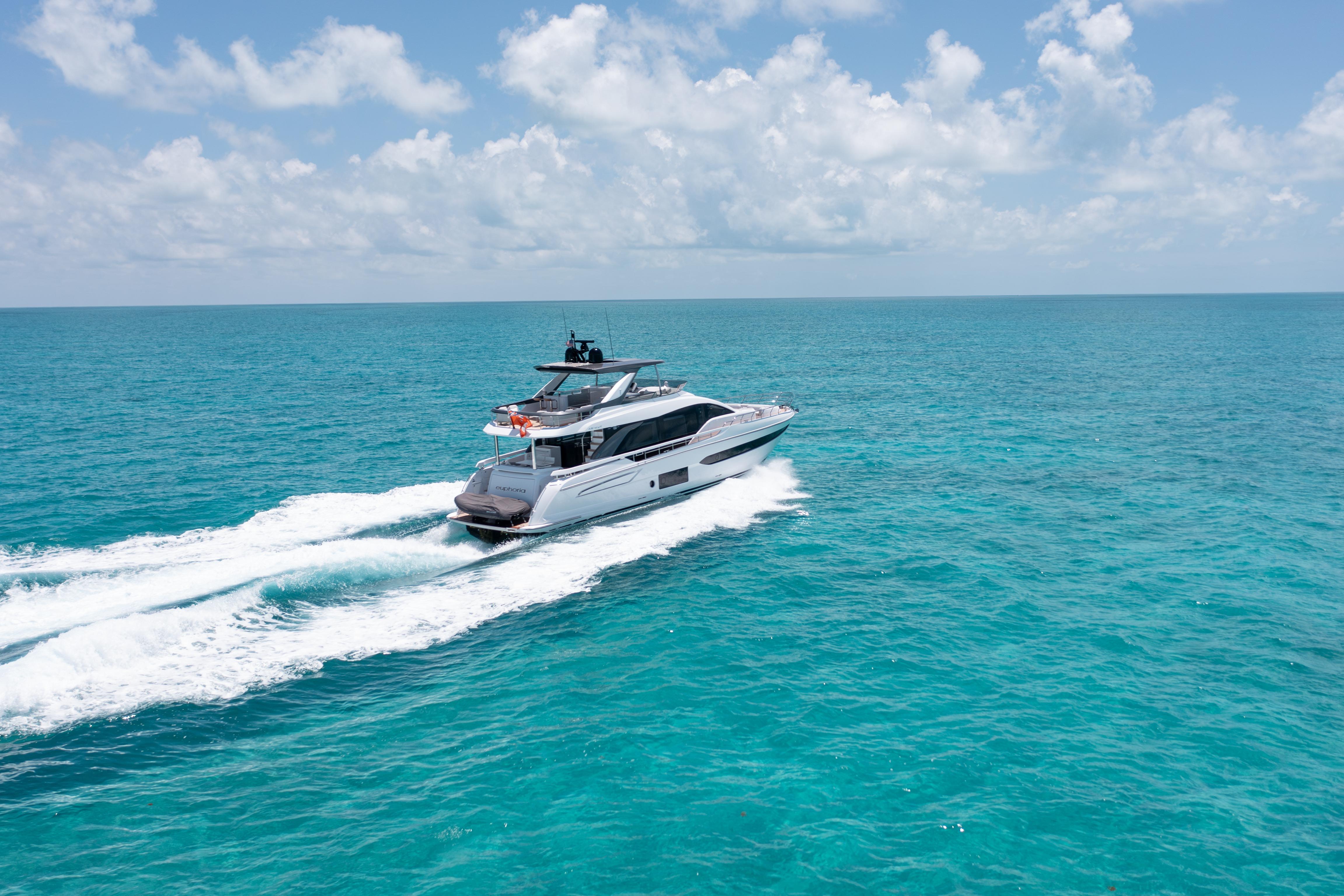 Luxury 2022 Azimut 78 yacht cruising on turquoise ocean under clear sky.