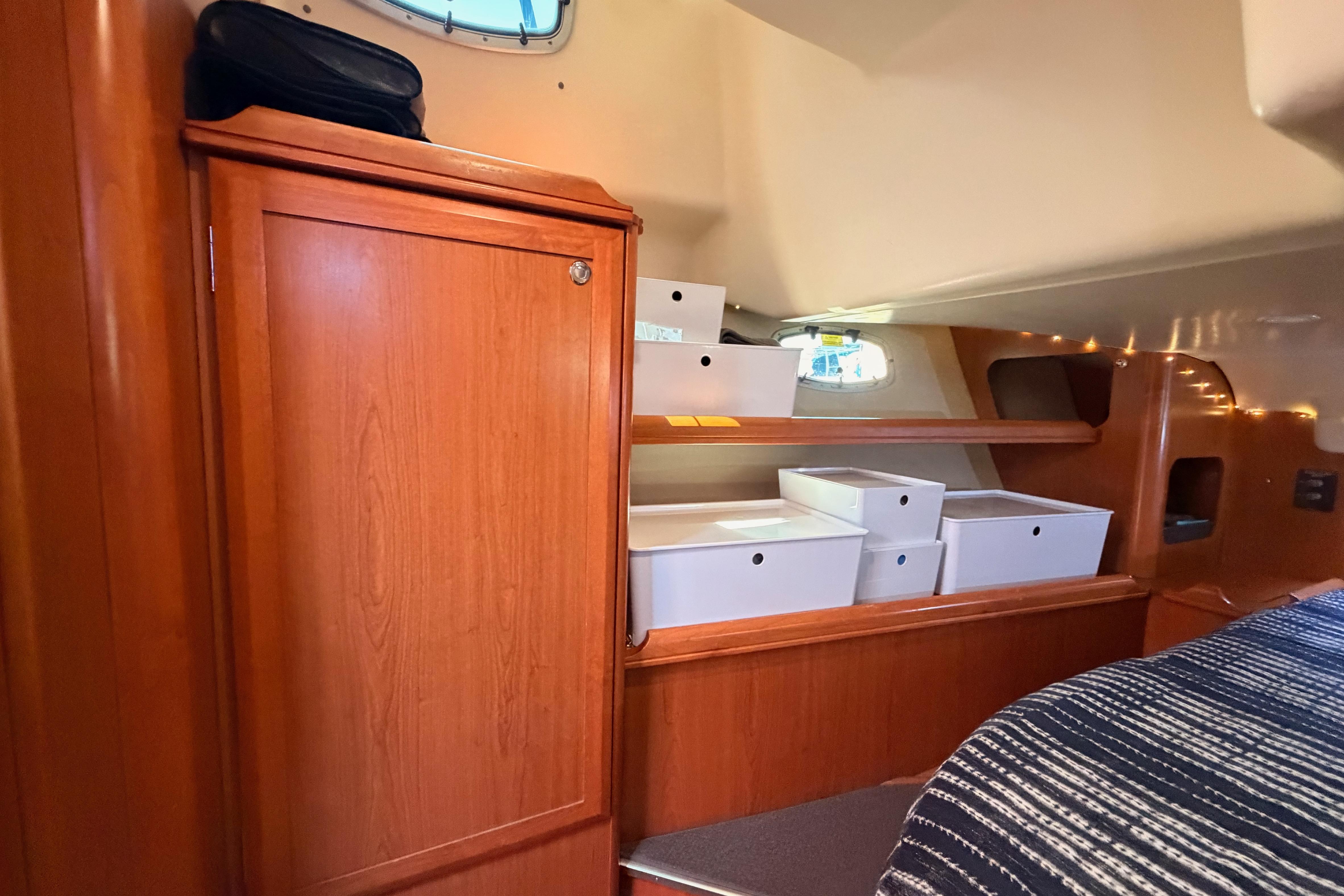 Interior of 2008 Hunter 45 Deck Salon with wooden cabinetry and organized storage boxes.