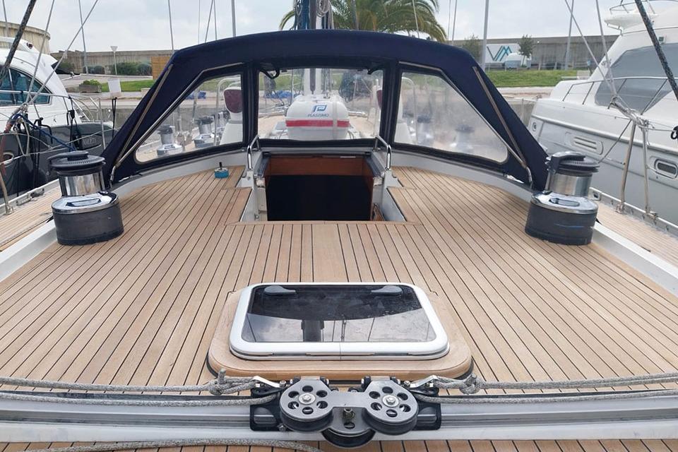 Deck view of 1990 Nautor Swan 59 sailboat with wooden finish and cockpit cover.