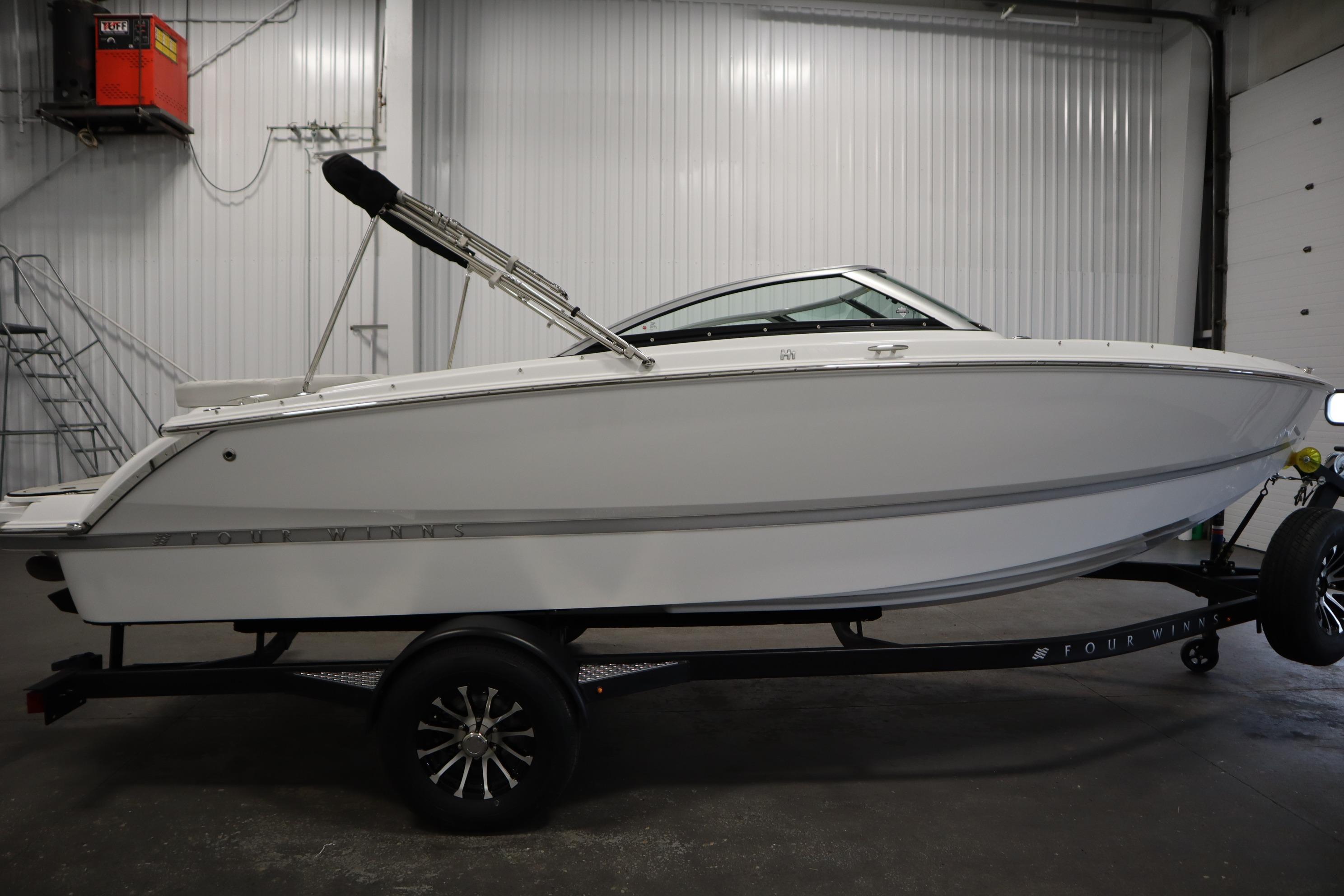 2026 Four Winns H1 Freedom boat on trailer in indoor storage facility.