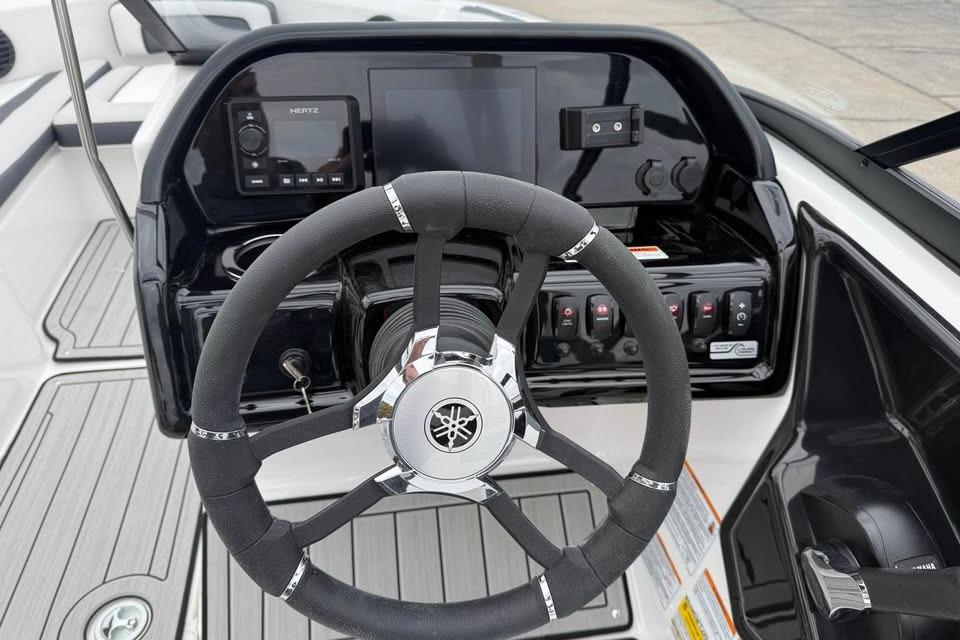 Steering wheel and dashboard of 2026 Yamaha Boats 195S, featuring modern controls and display.