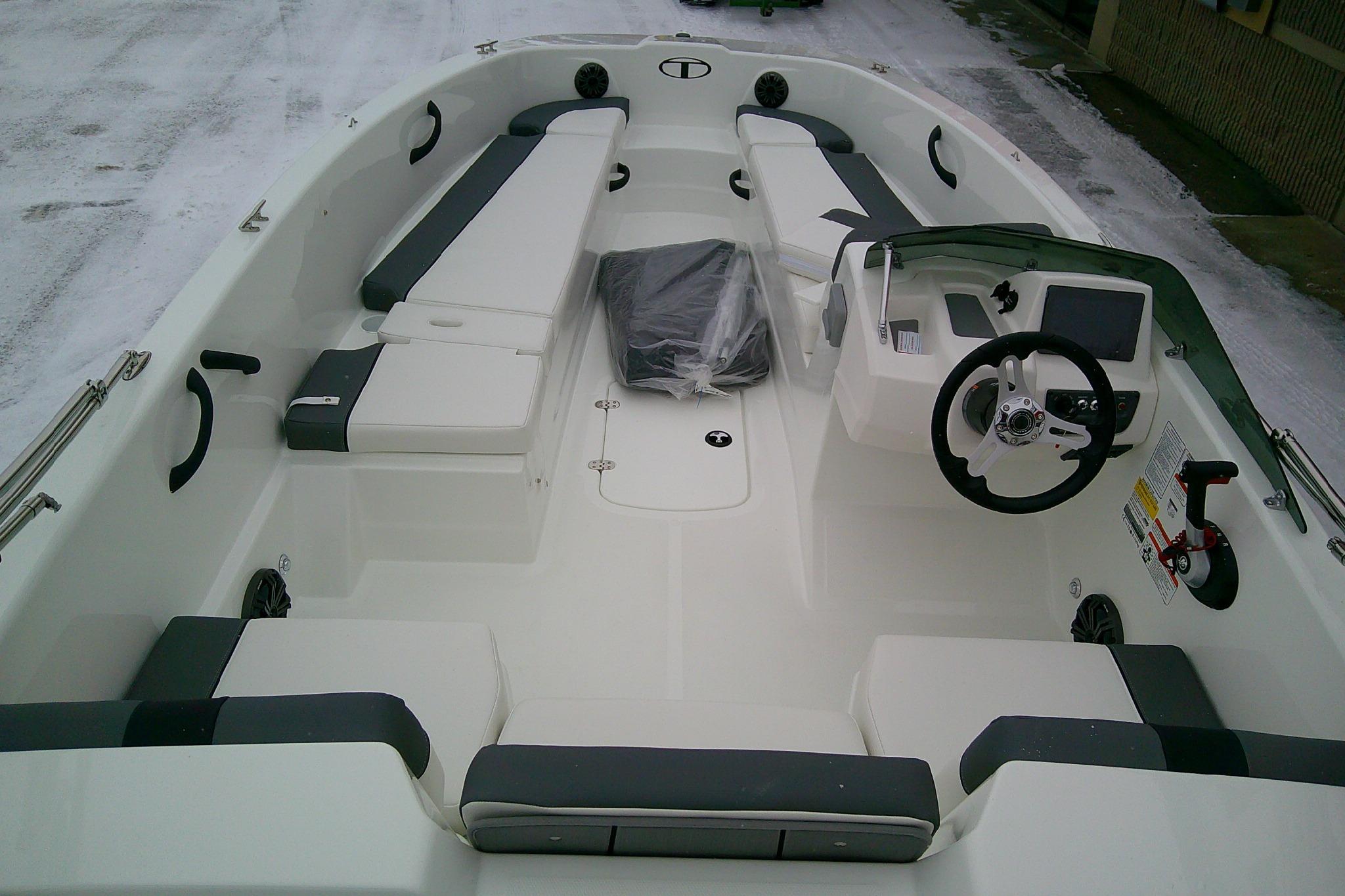 2026 Tahoe T18 boat interior with seating and steering console, parked on snowy ground.