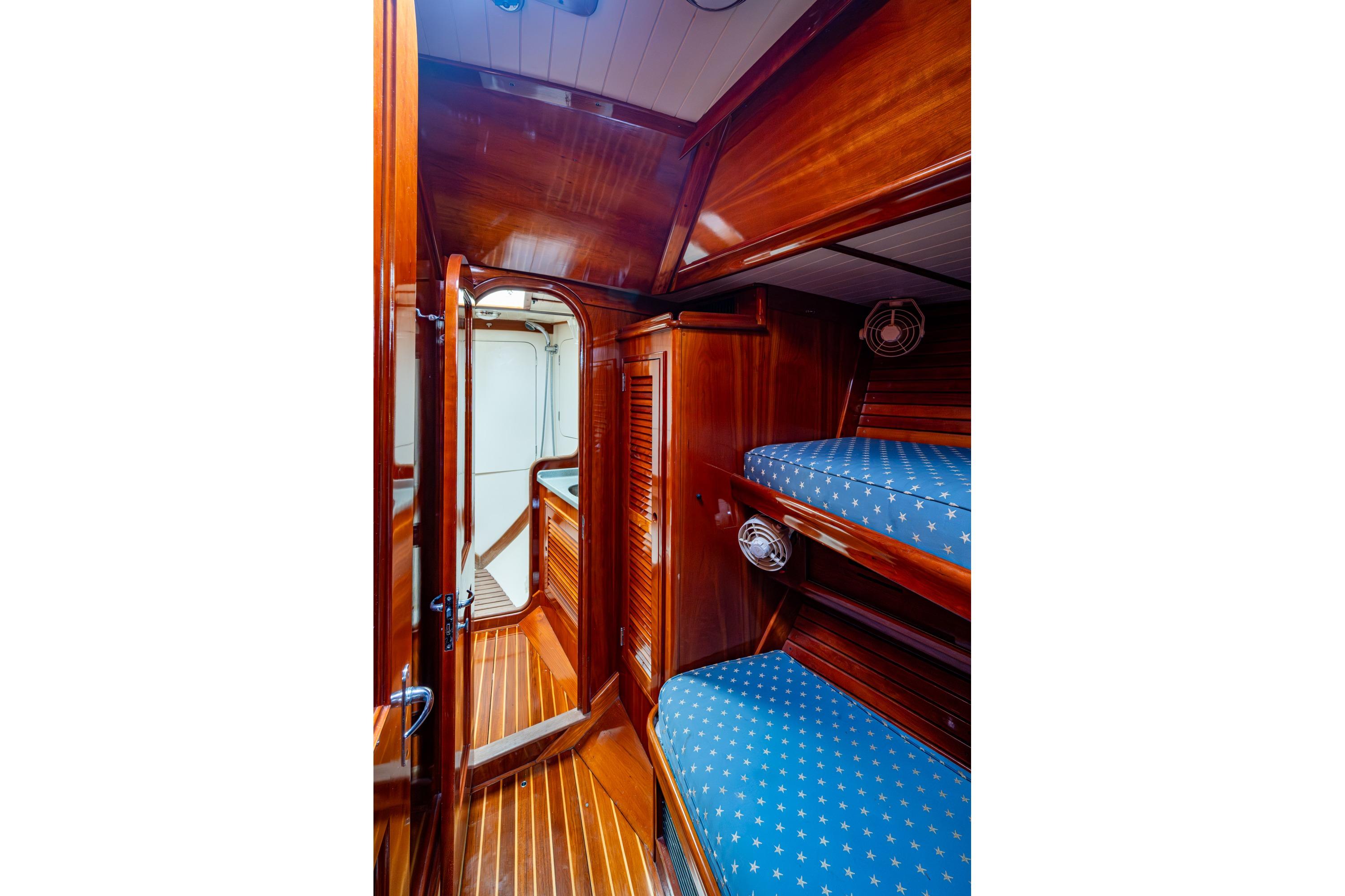 Hinckley Sou'wester Stoway Sloop 2000 interior with wooden finish and blue star-patterned bunks.