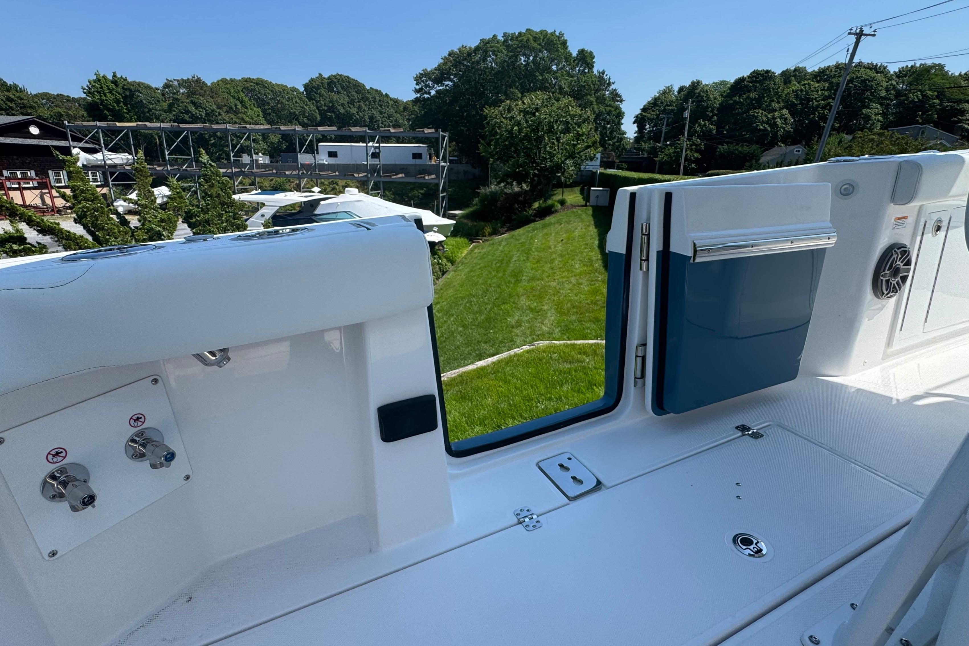 2026 Edgewater 250CC boat interior with open hatch and scenic outdoor view.