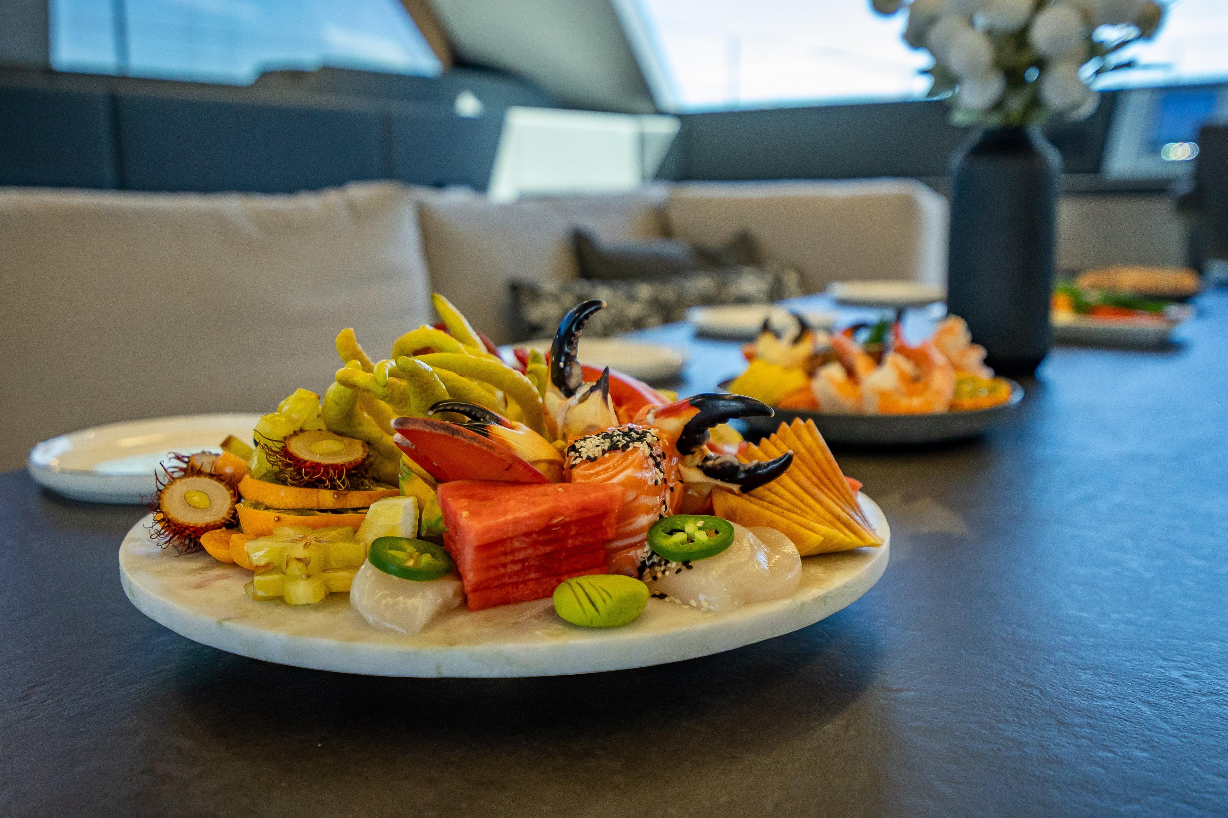 Luxurious dining setup on 2026 Sunreef 60 Power yacht with gourmet seafood platter.