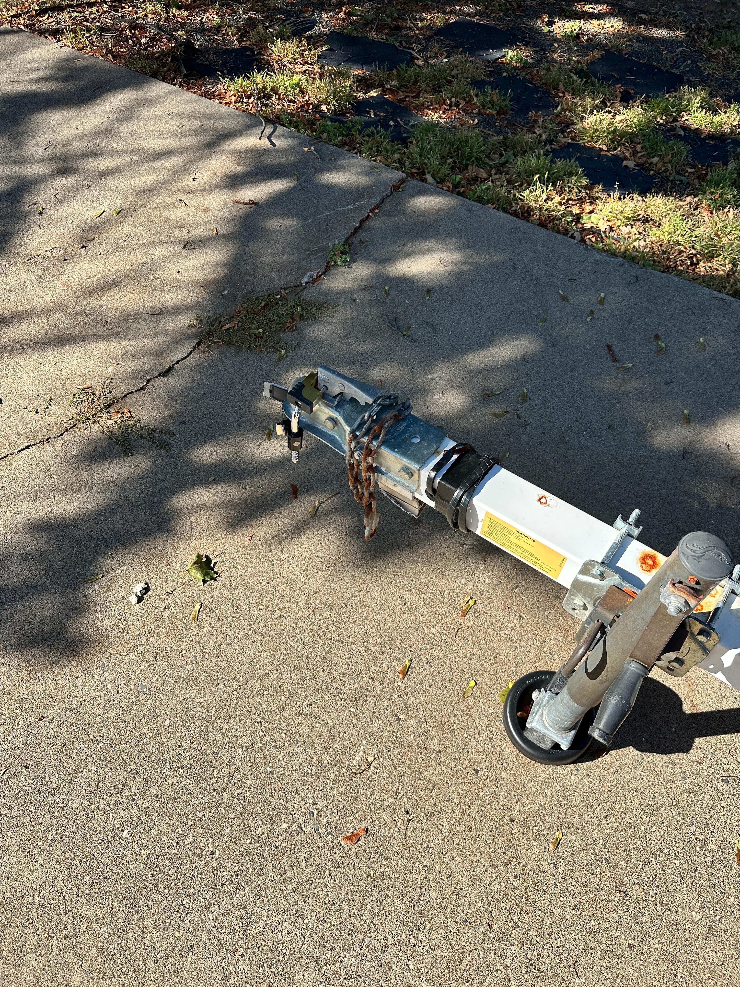 Trailer hitch on pavement, Lund H model, 1960, with chain and wheel.