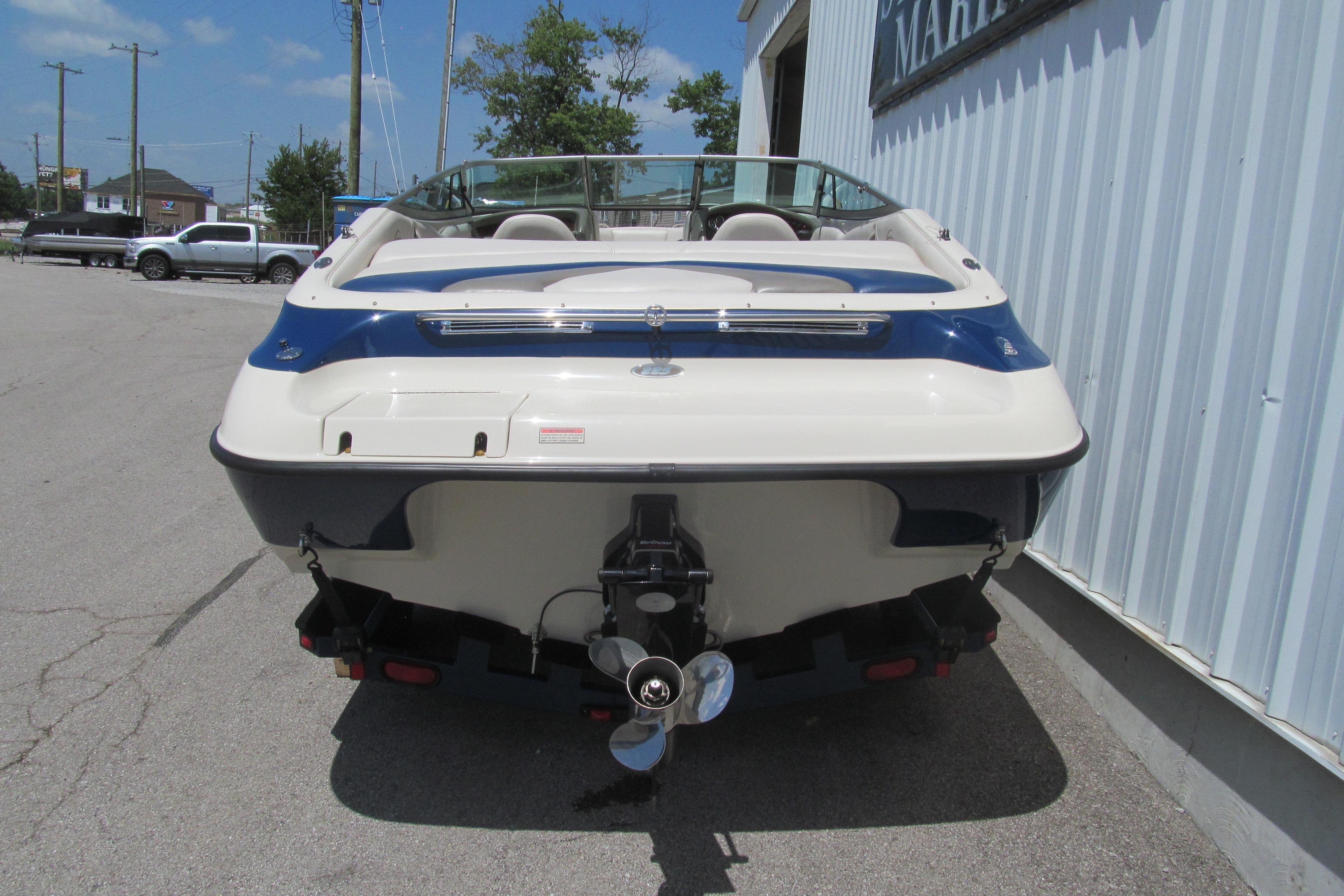 2001 Crownline 225 BR boat, rear view, parked outdoors near a building.