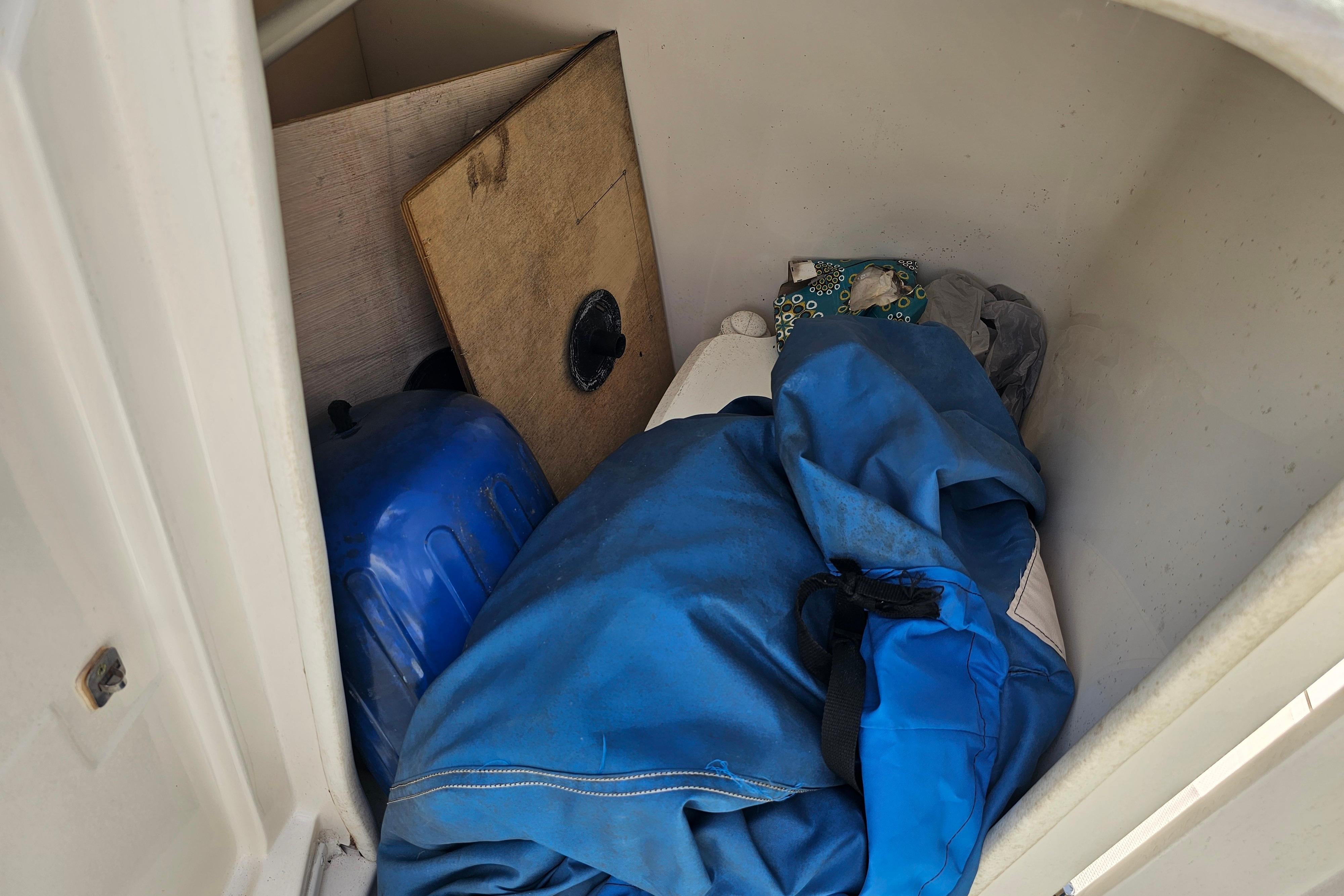 Storage compartment in a 2008 Monterey 220 Explorer boat with various items.