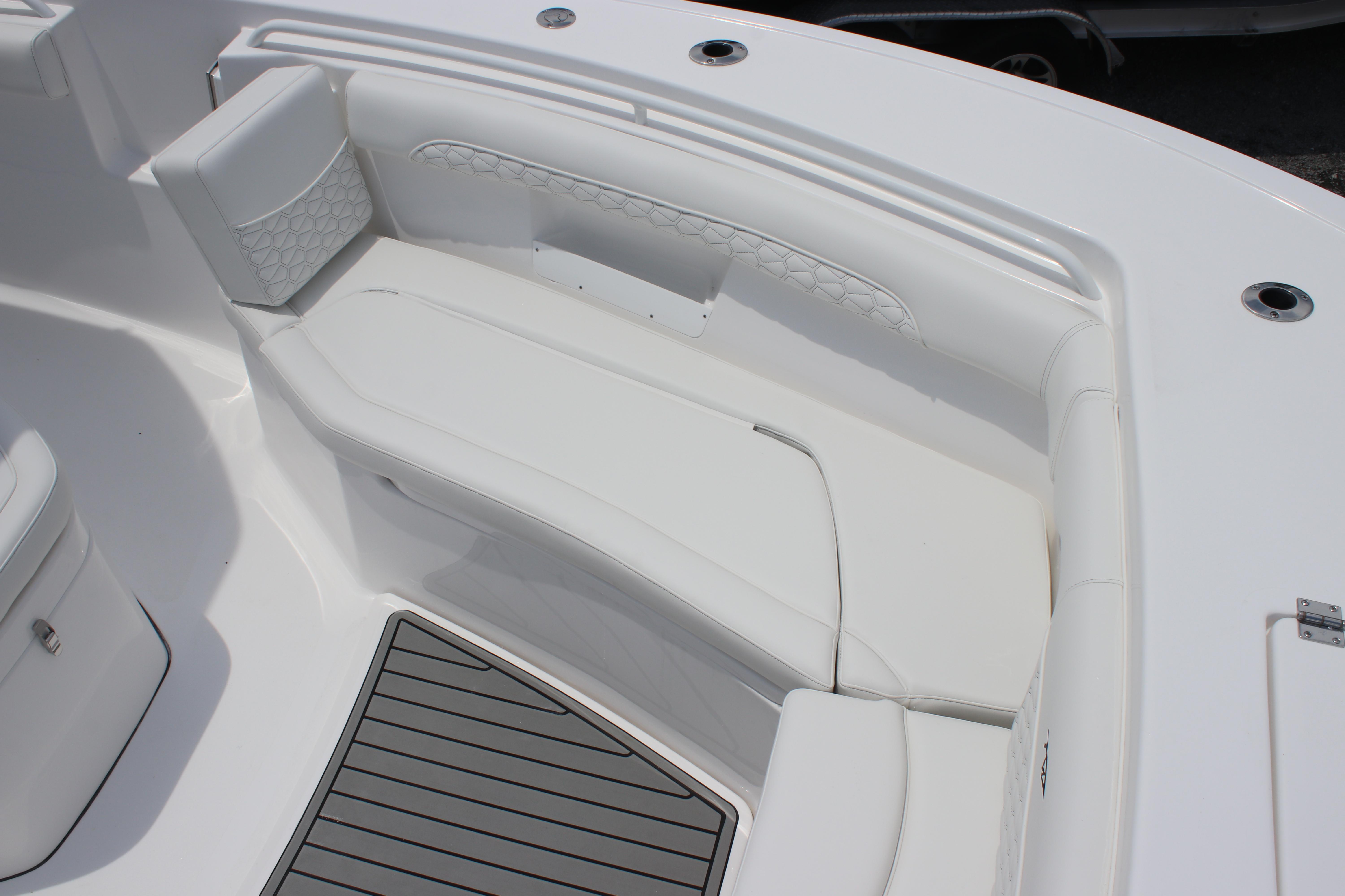 2026 Tidewater 272 LXF boat interior with white cushioned seating and gray flooring.