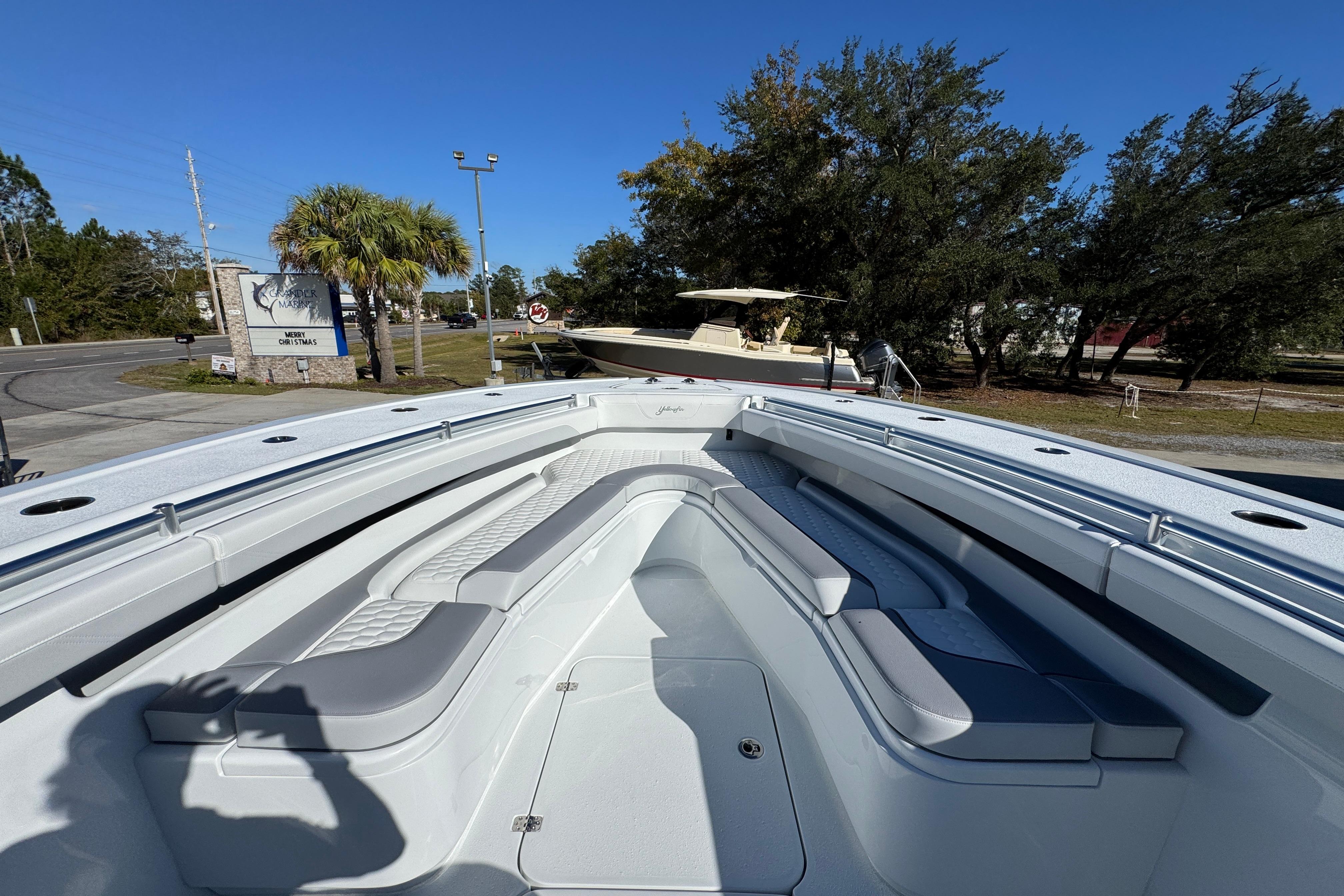 2026 Yellowfin 36 Offshore boat with spacious seating, parked outdoors under clear blue sky.