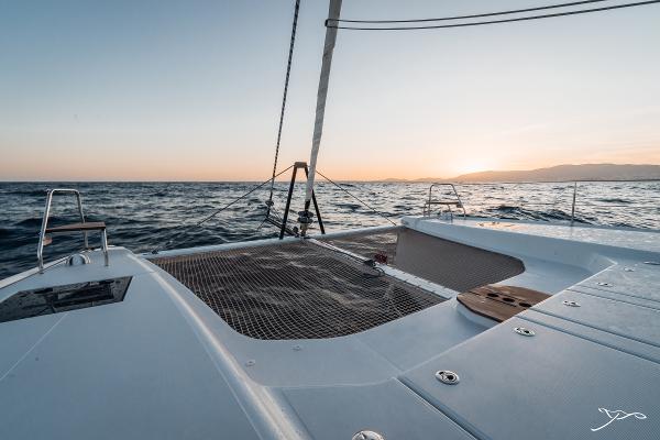 2025 Nautitech 44 Open catamaran sailing at sunset on open sea.