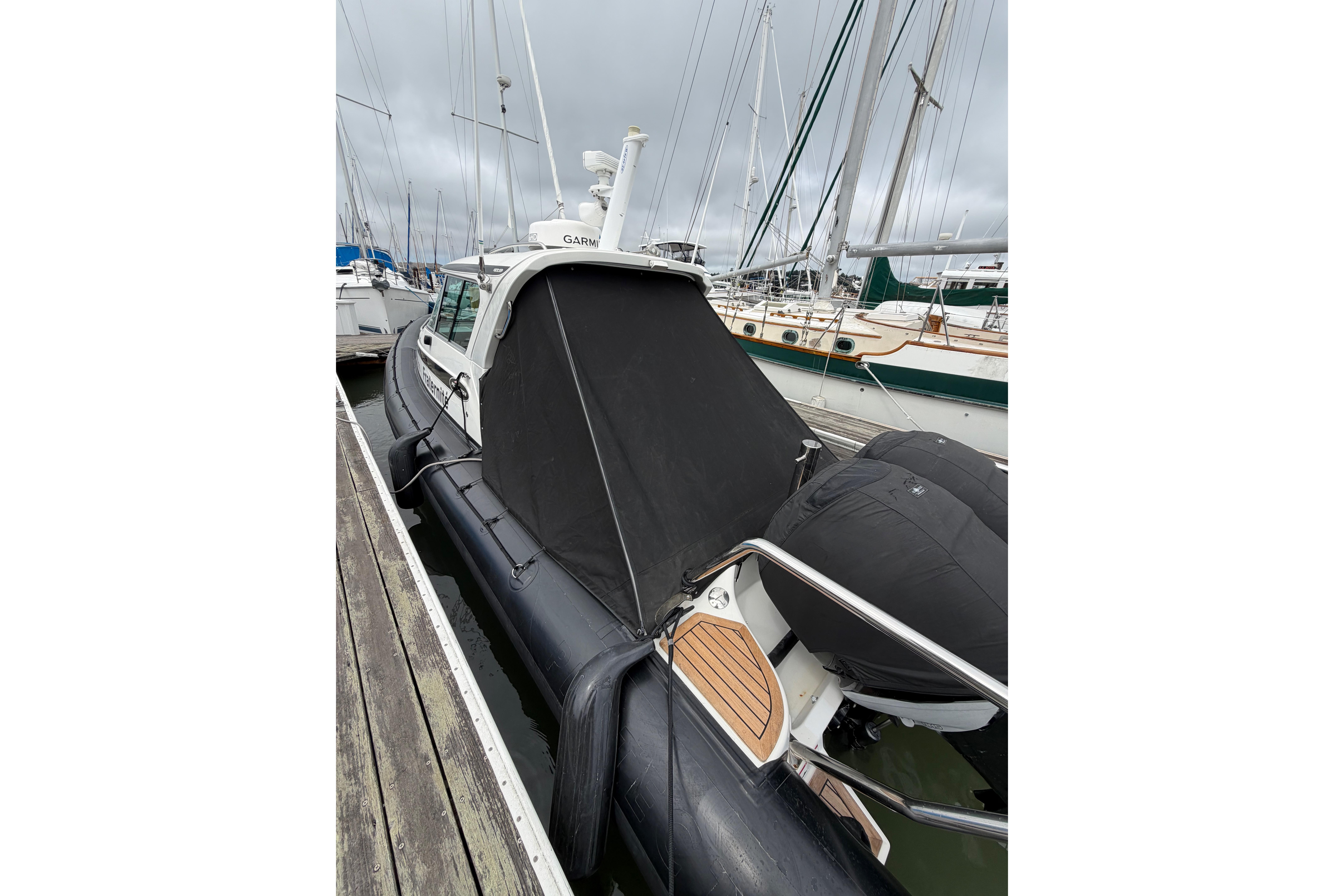 2016 Protector Targa 30 boat docked, featuring a covered cabin and sleek design.
