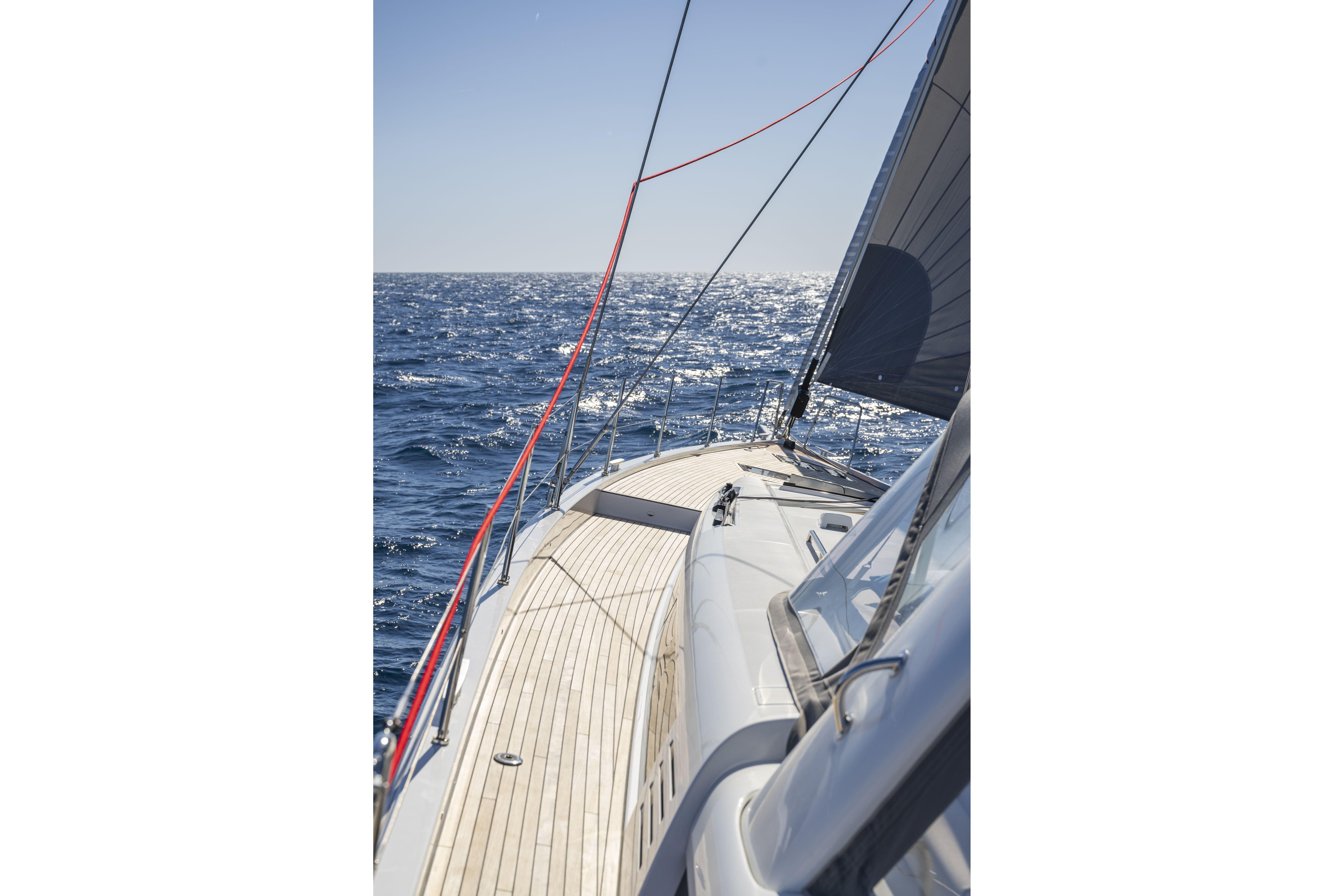2023 Beneteau Oceanis Yacht 60 sailing on open sea under clear sky.
