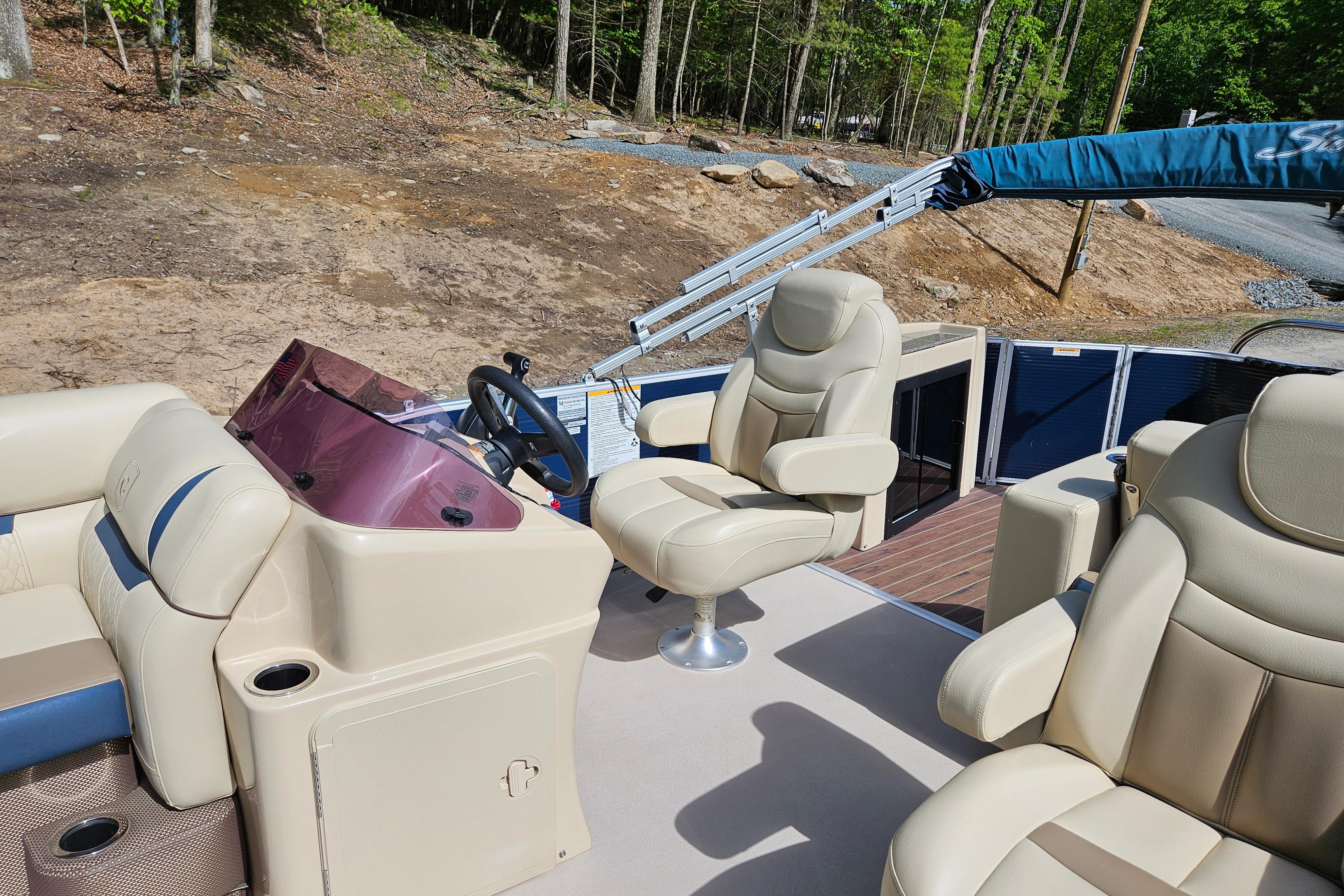 2019 Sweetwater 2086 boat interior with beige seating and steering console.