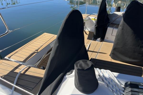 2025 Hanse 360 yacht deck with covered equipment and sleek wooden finish.