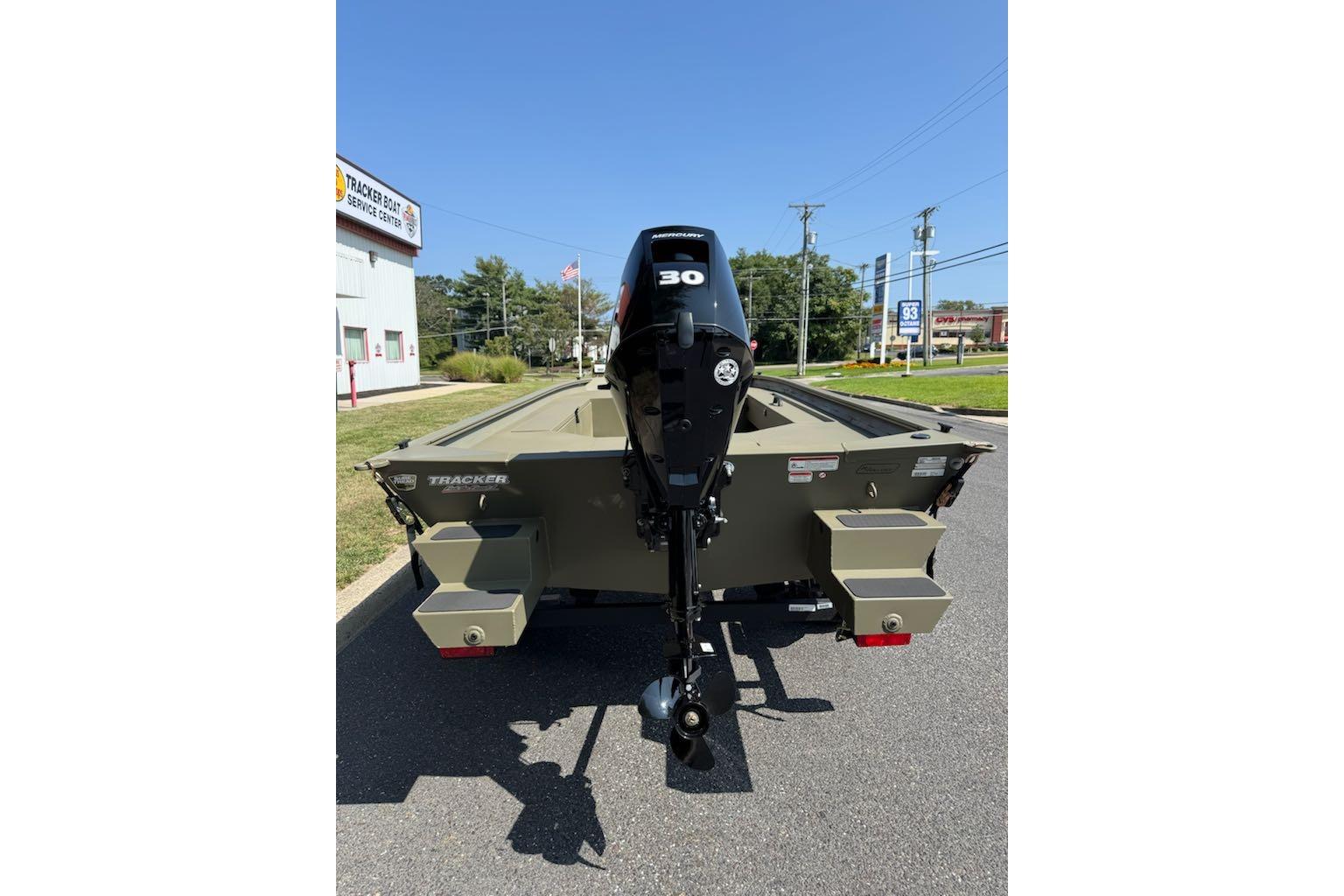 2026 Tracker Grizzly 1654 T Sportsman boat with 30 HP motor, parked outdoors.