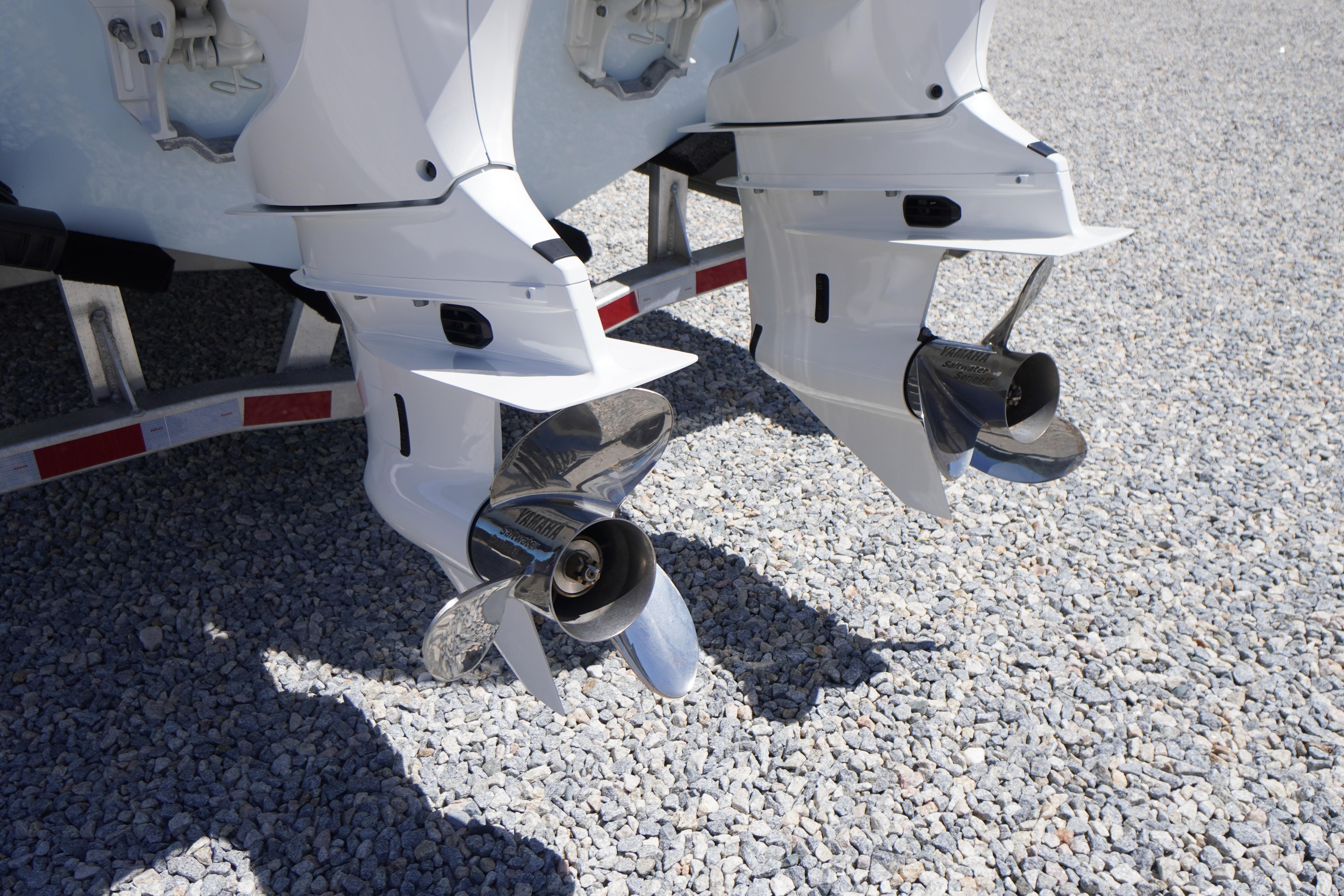 Twin outboard motors on a 2026 Tidewater 302 CC Adventure boat, displayed on gravel.