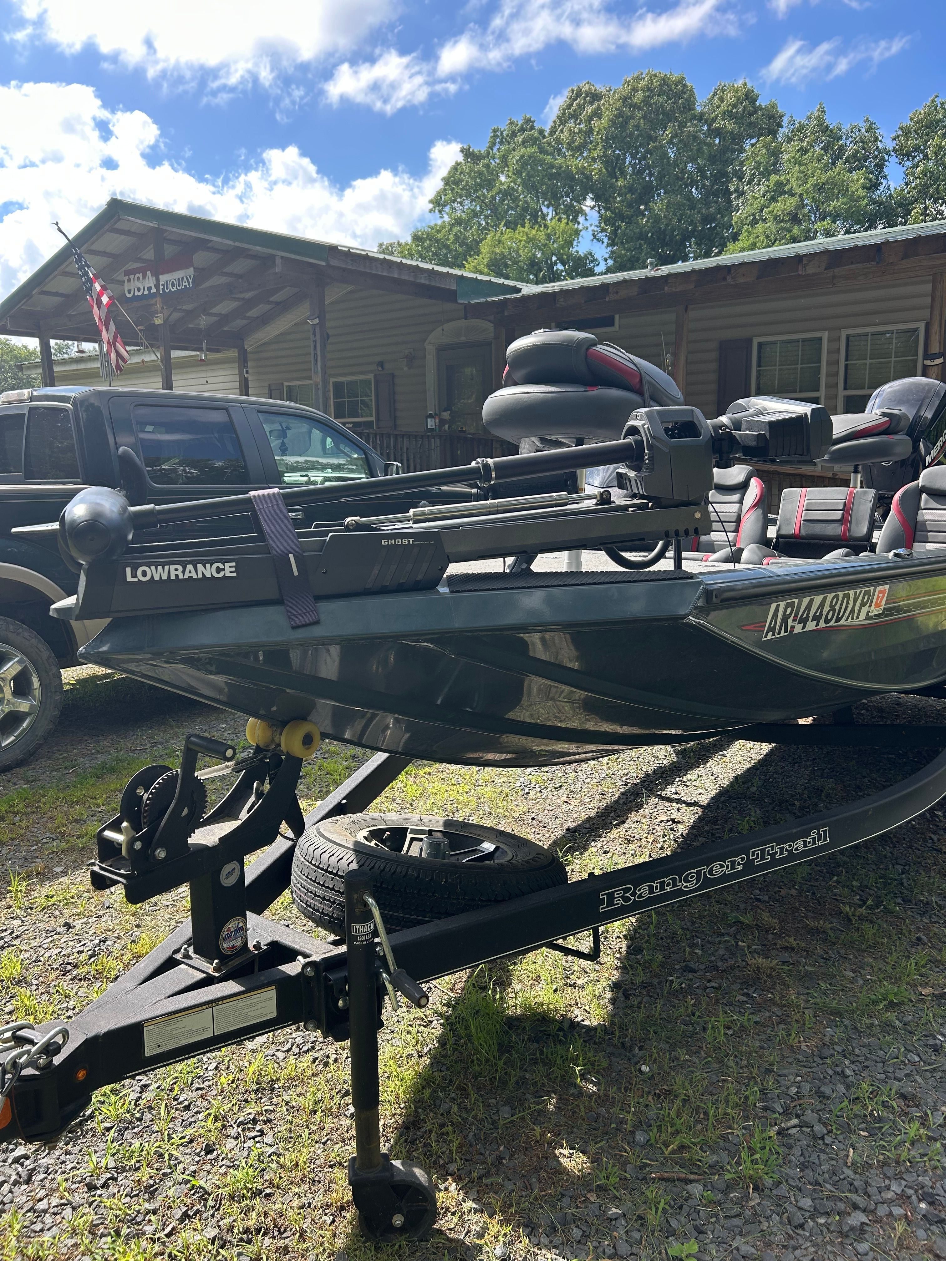 A Ranger RT178 boat on a trailer in front of a house with an American flag.