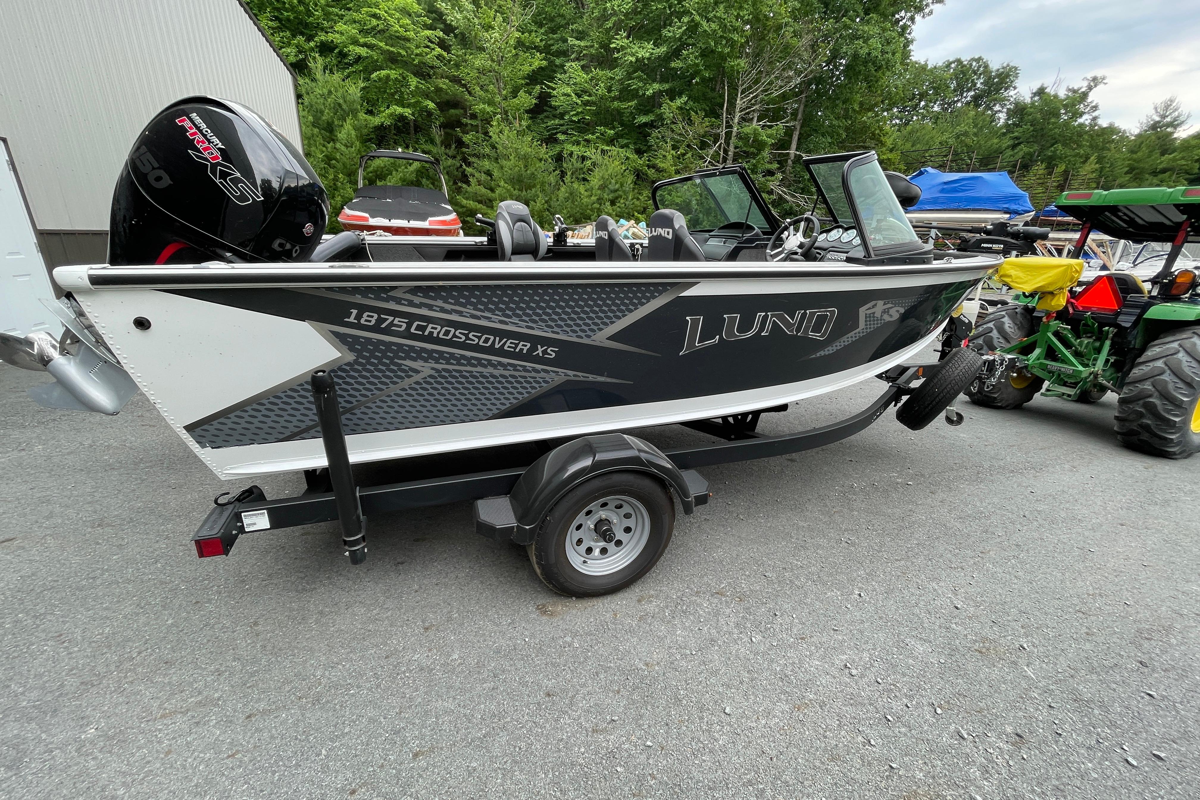 2022 Lund 1875 Crossover XS boat on trailer, parked outdoors.