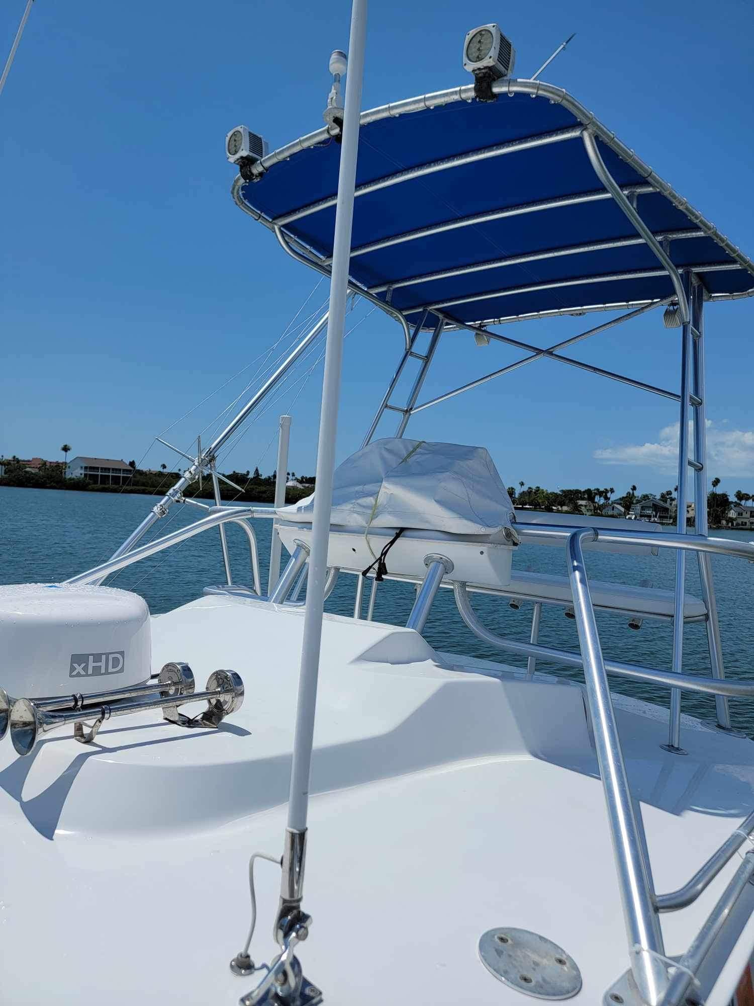 1997 Luhrs 32 Open boat with blue canopy, docked on a sunny day.