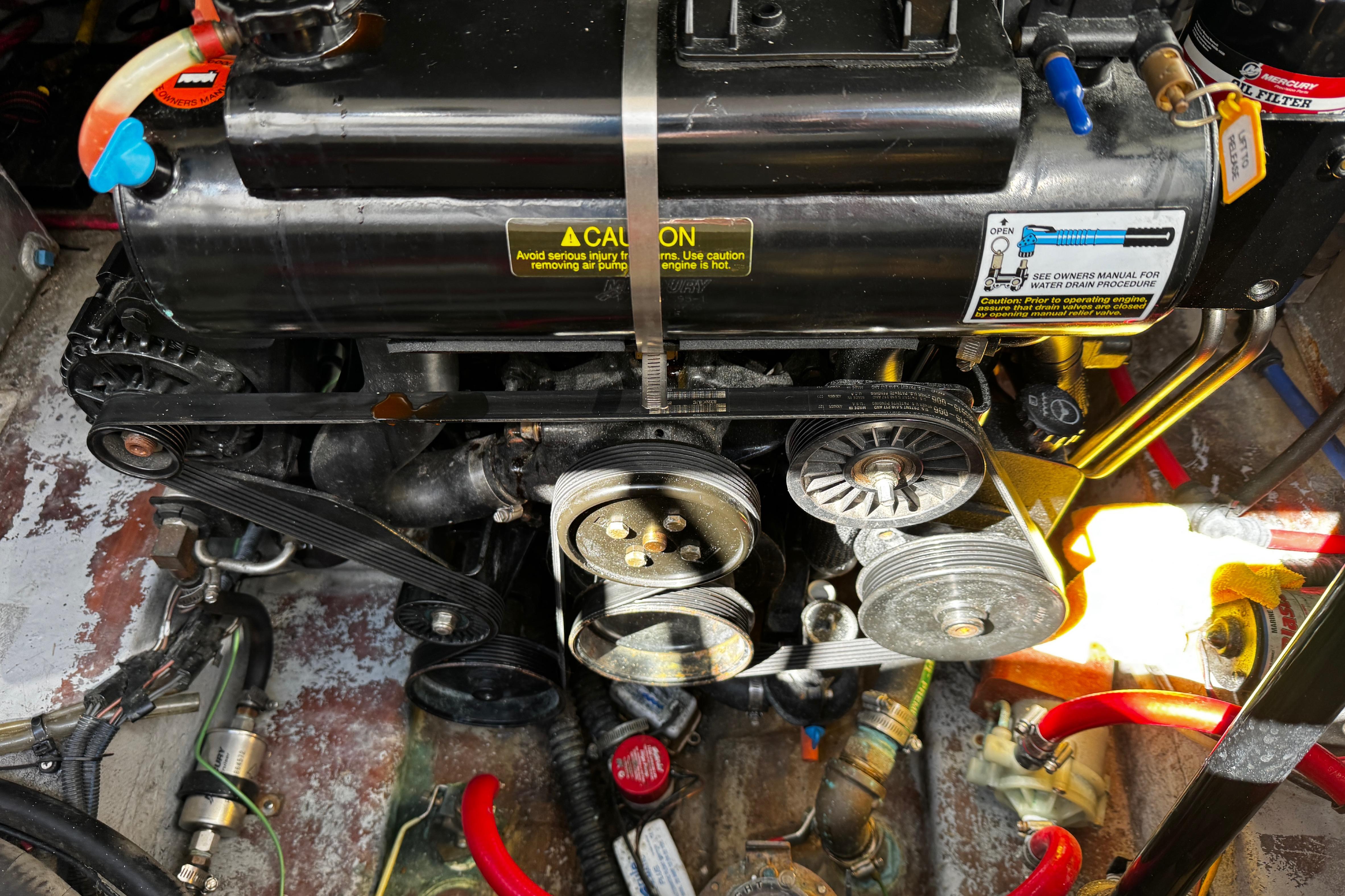 Engine compartment of a 2004 Crownline 250 CR boat, showing belts and pulleys.