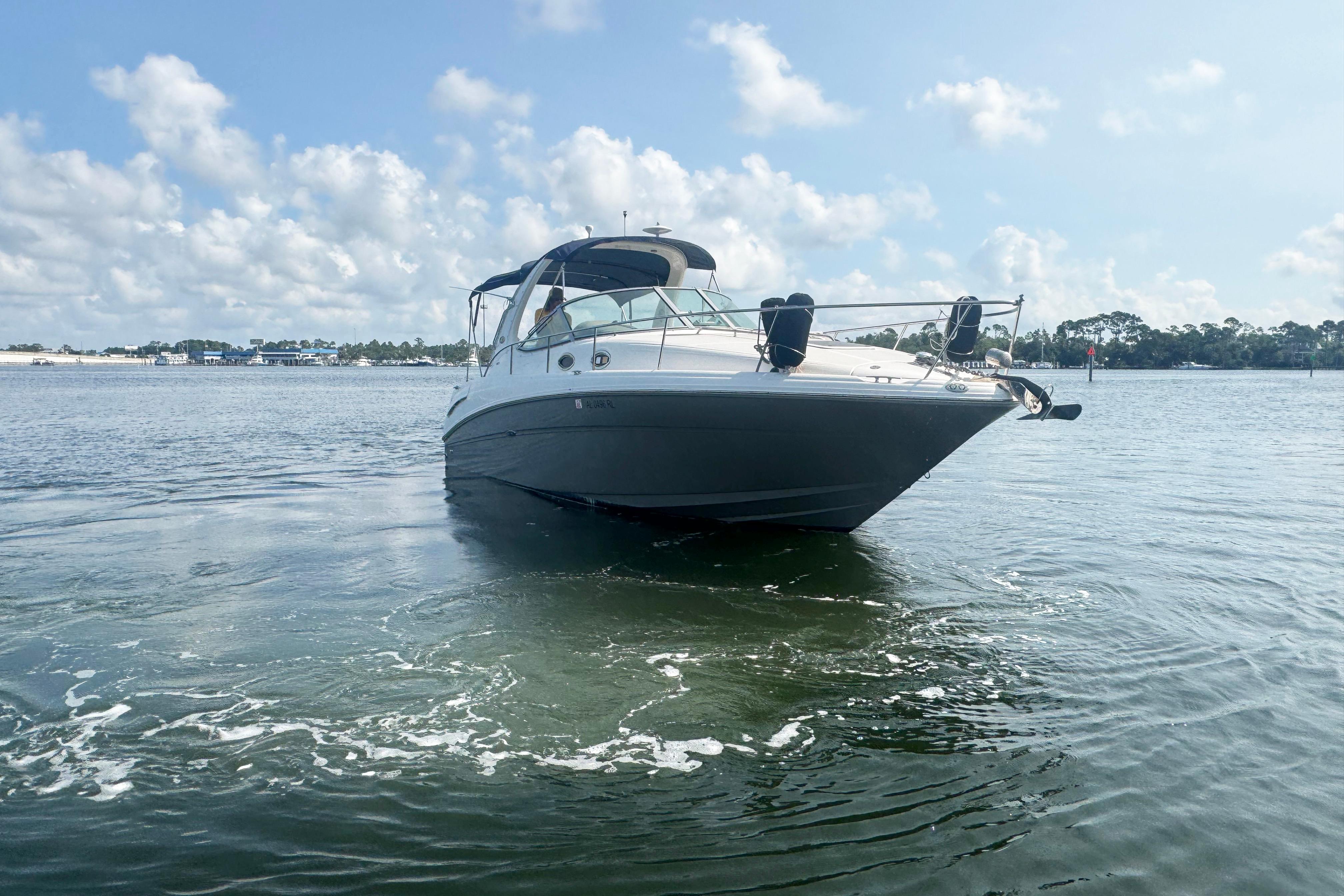 2006 Sea Ray 300 Sundancer boat on calm water under a partly cloudy sky.