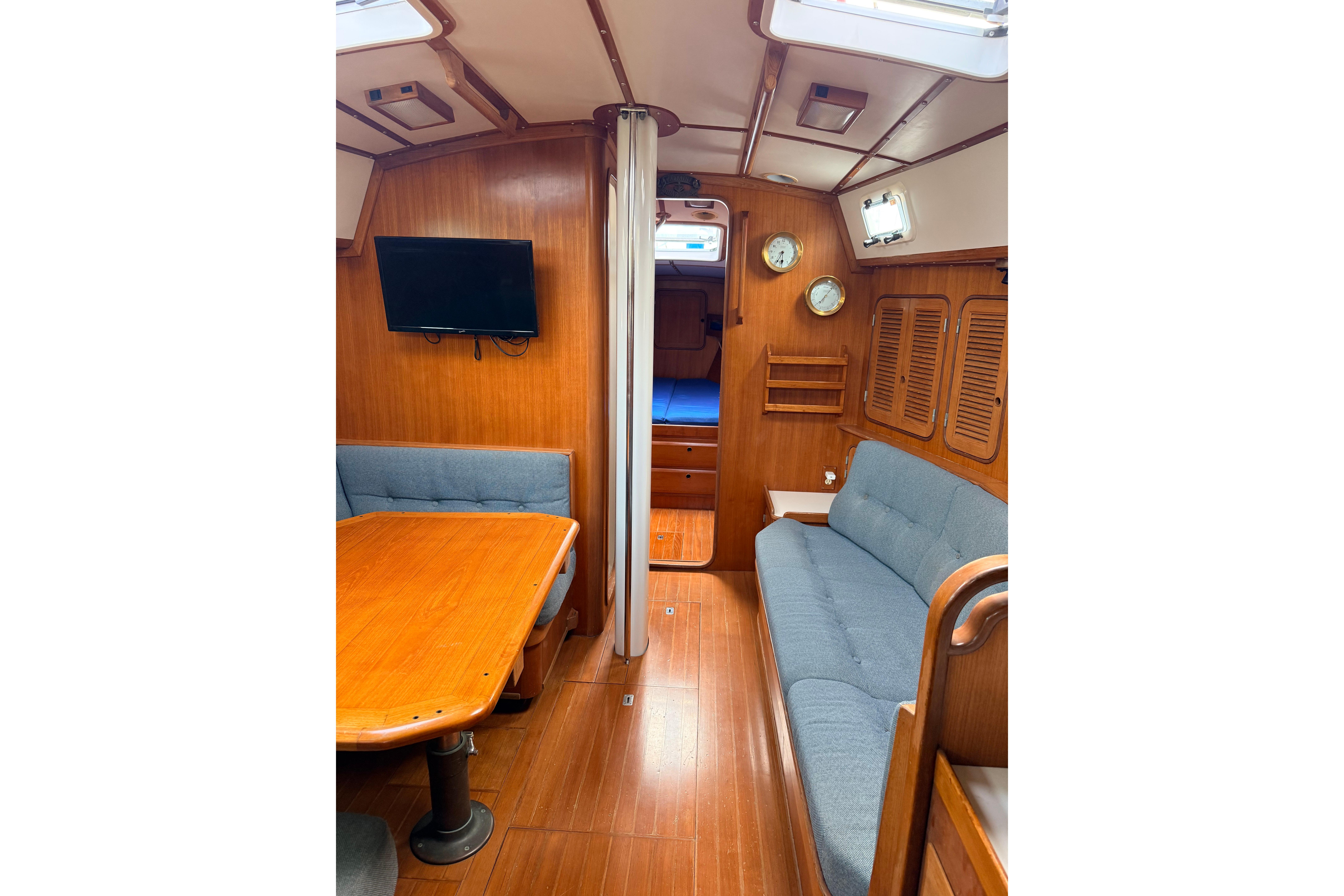 Interior of 1987 Norseman 400 sailboat with wooden furnishings and cozy seating area.