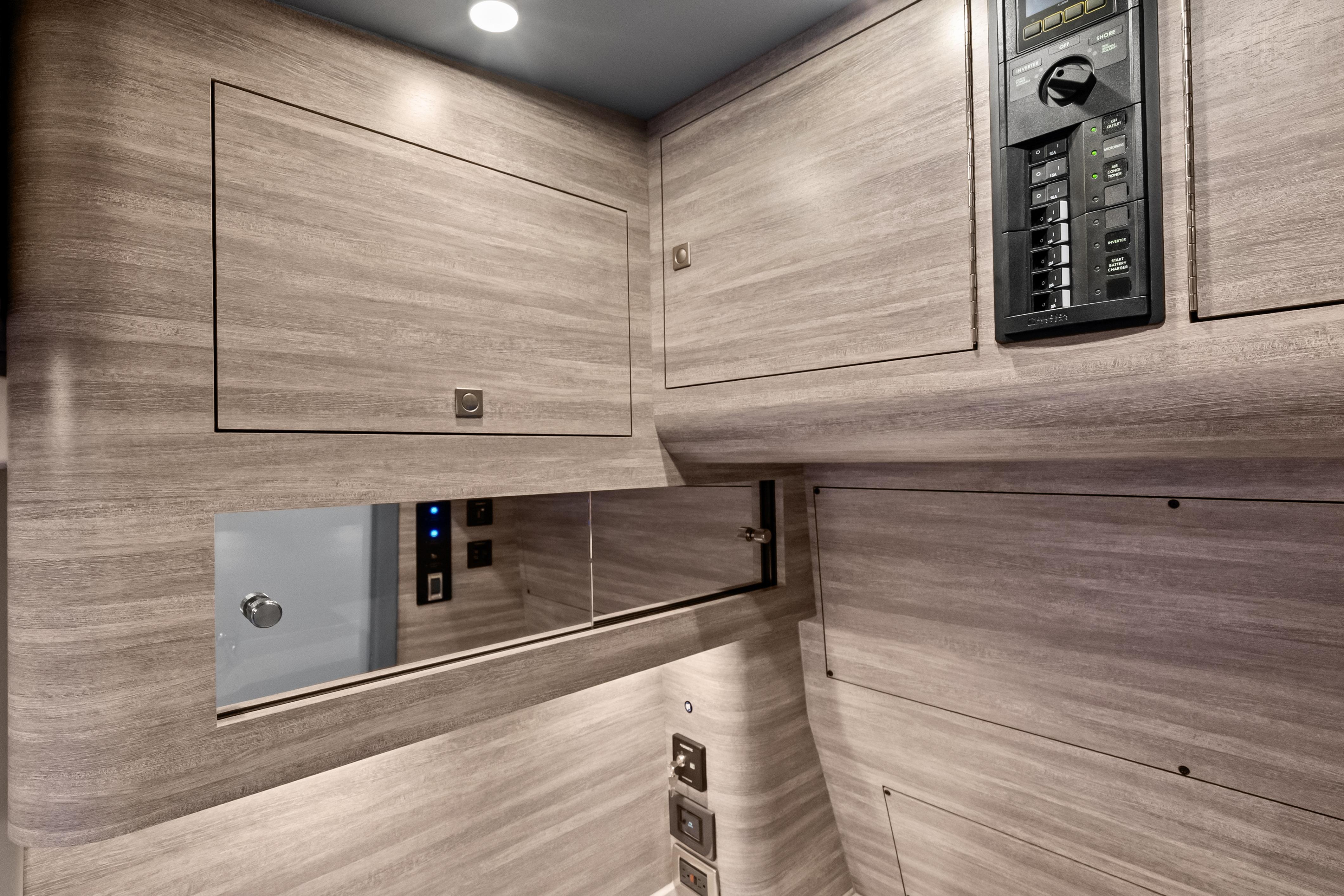 Interior of 2027 Mystic Powerboats M4200, featuring sleek wood paneling and control panel.