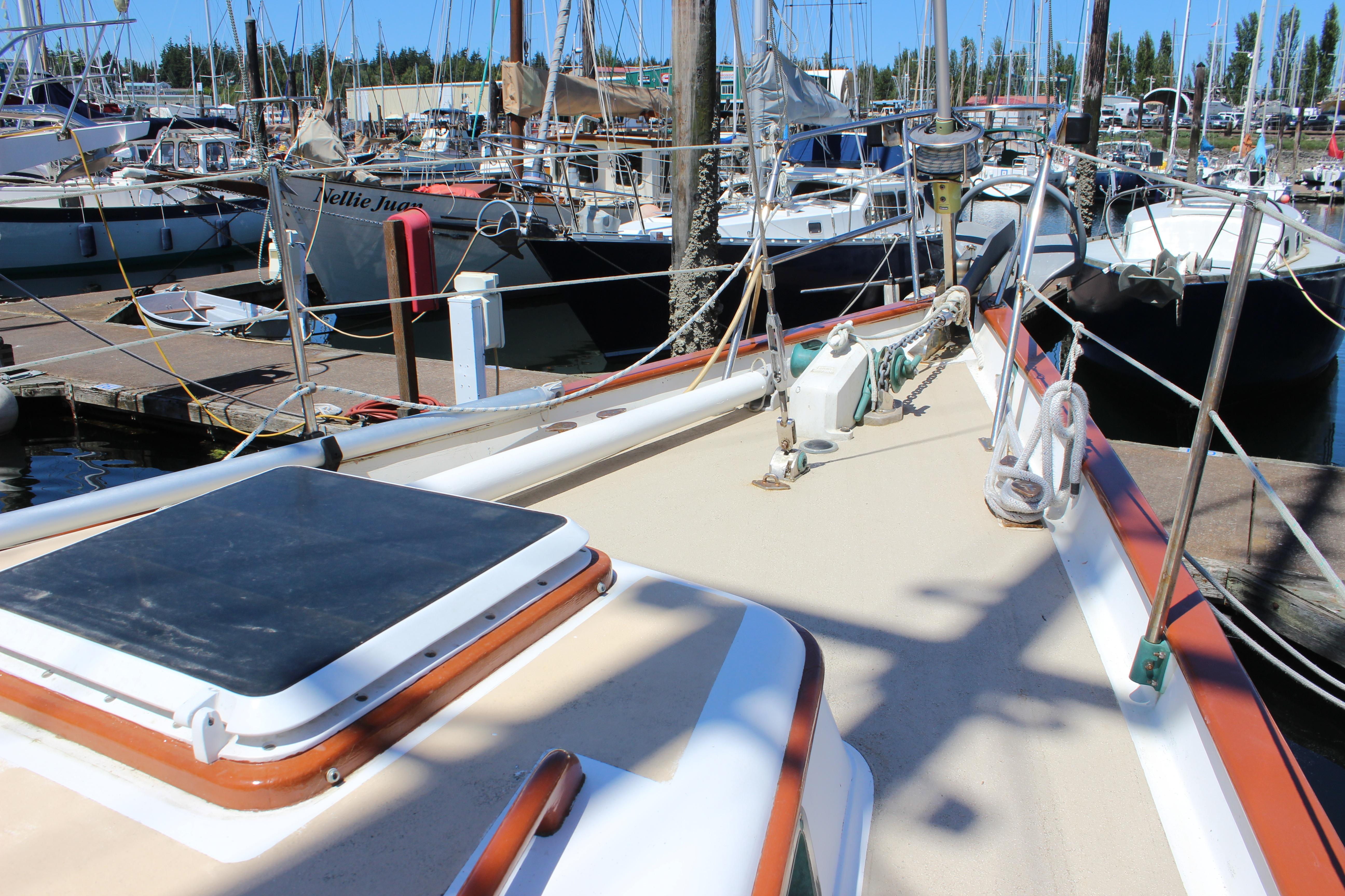 1981 Kelly Peterson 46 sailboat docked in a marina, surrounded by other boats.