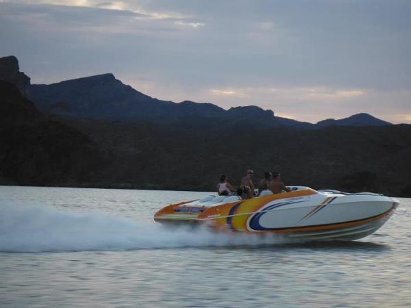 2001 Eliminator Eagle speedboat cruising on a lake at sunset.