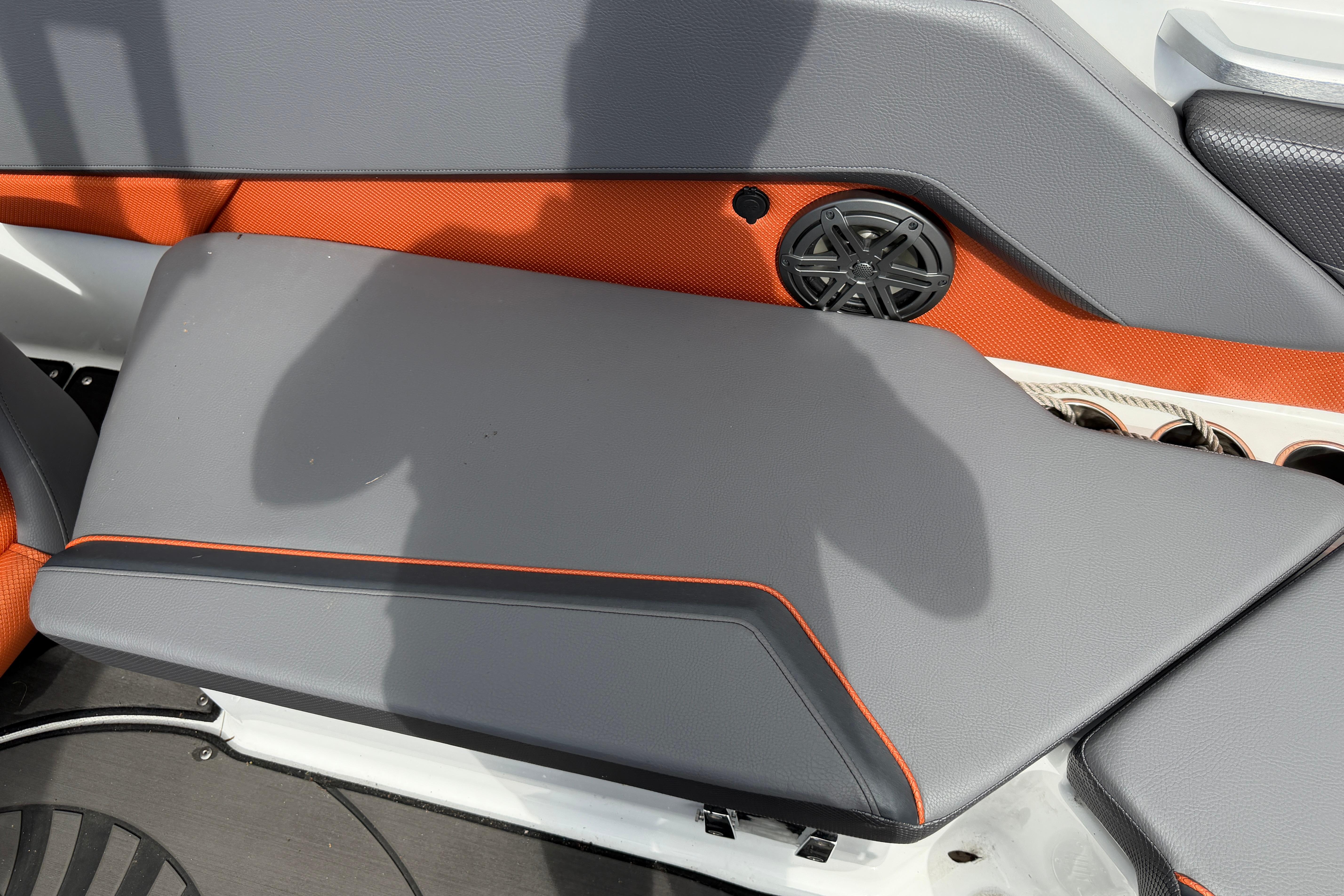 2026 Scarab 235 LX boat interior with gray and orange seating, speaker, and cup holders.