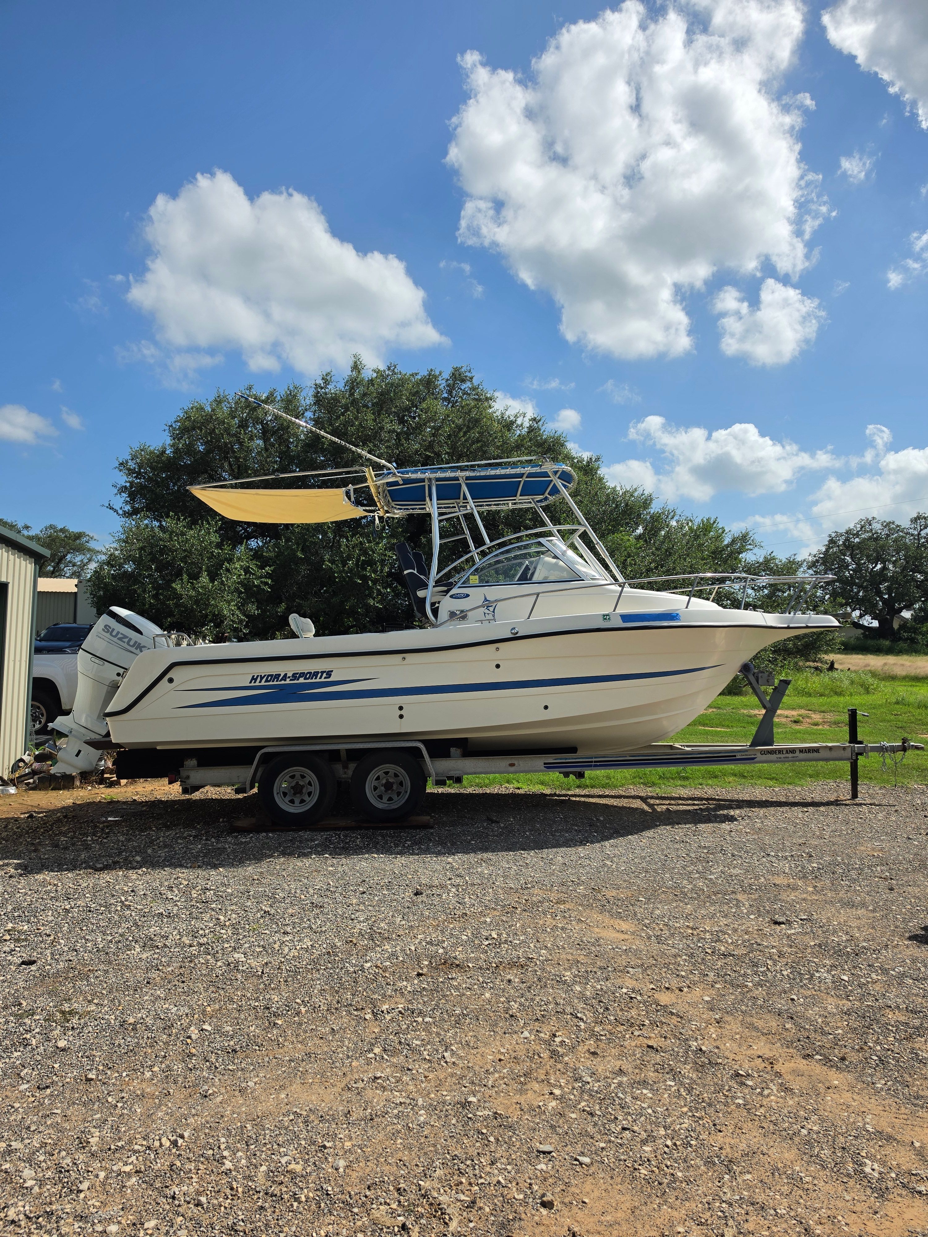 1998 Hydra-Sports 2450 on a trailer, featuring a sunshade and outboard motor.