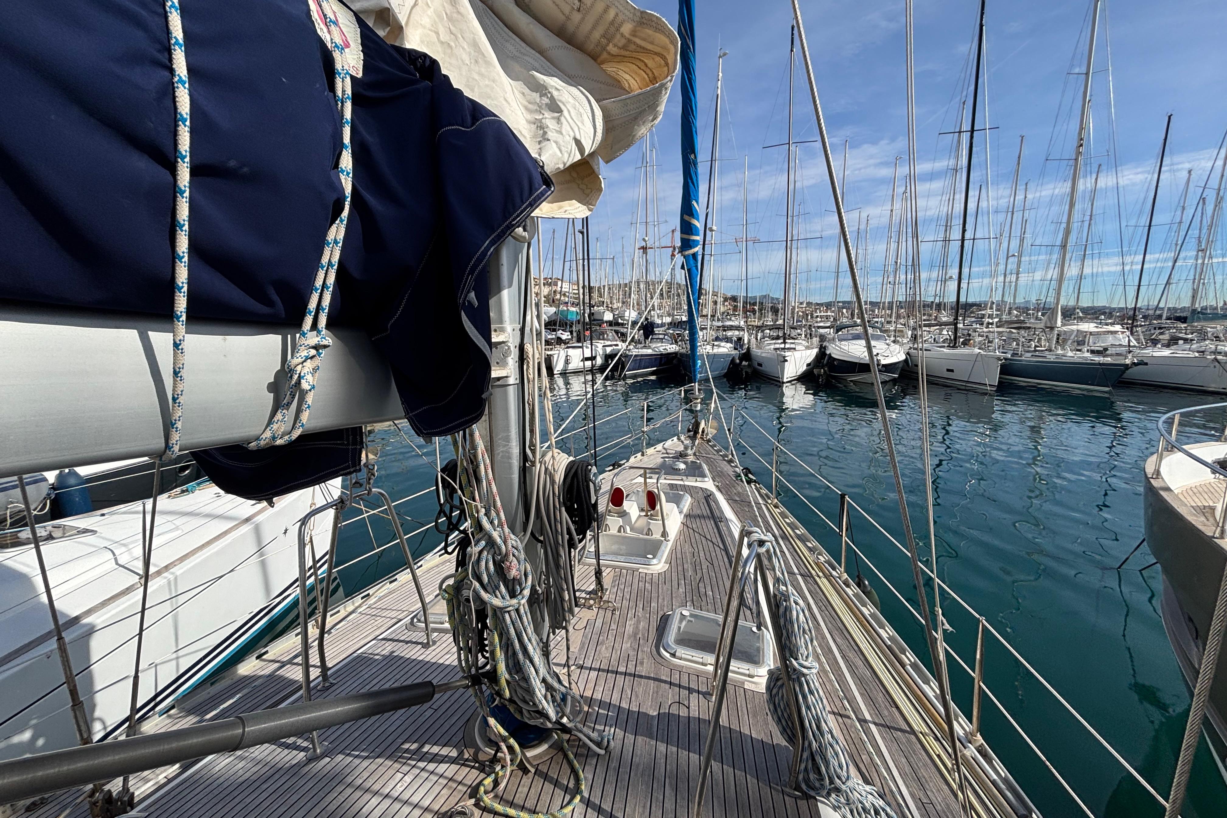 Sailboat deck view of 1997 Wauquiez Centurion 48S in a marina, surrounded by yachts.