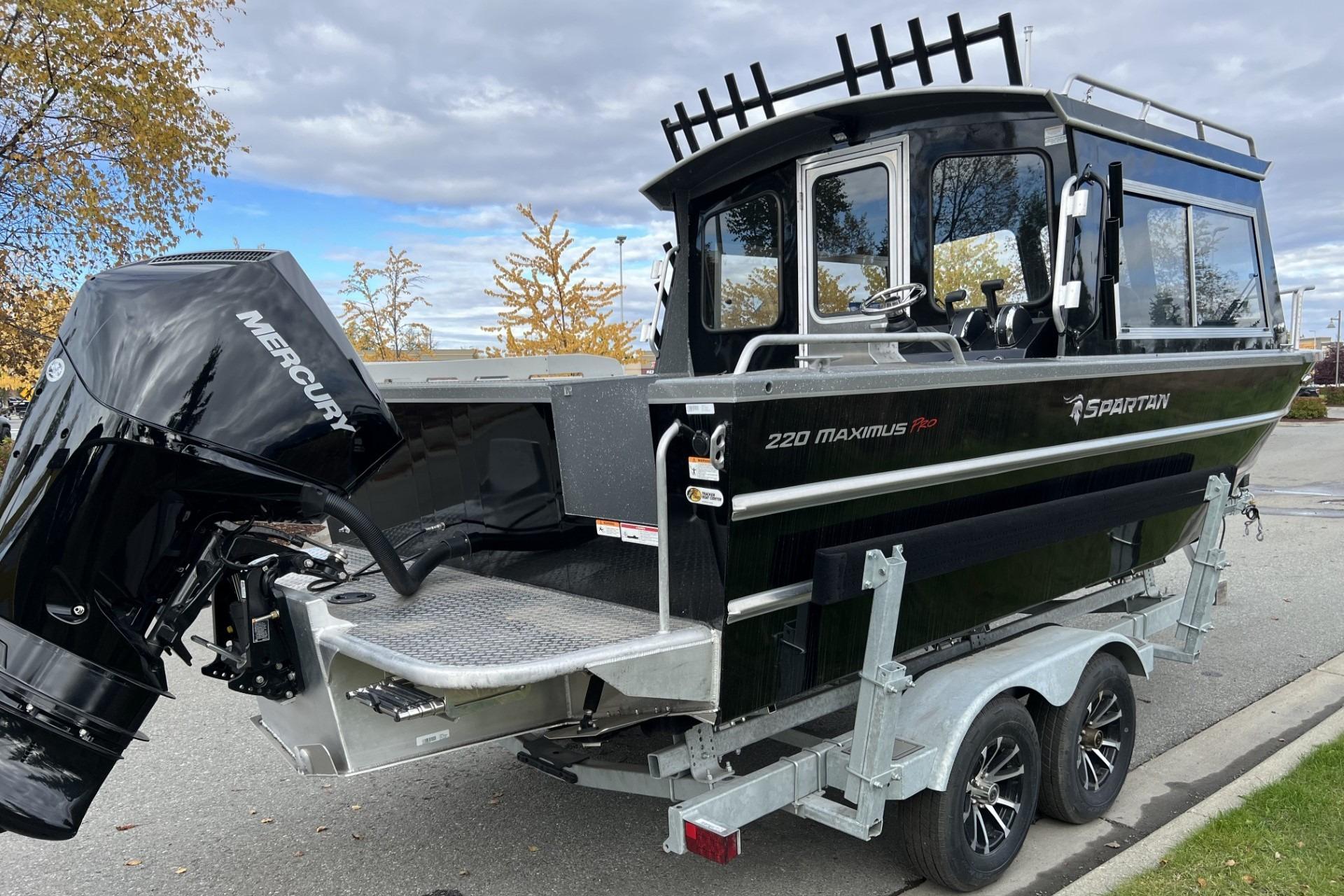 2024 Spartan 220 Maximus boat with Mercury engine on trailer, parked outdoors.