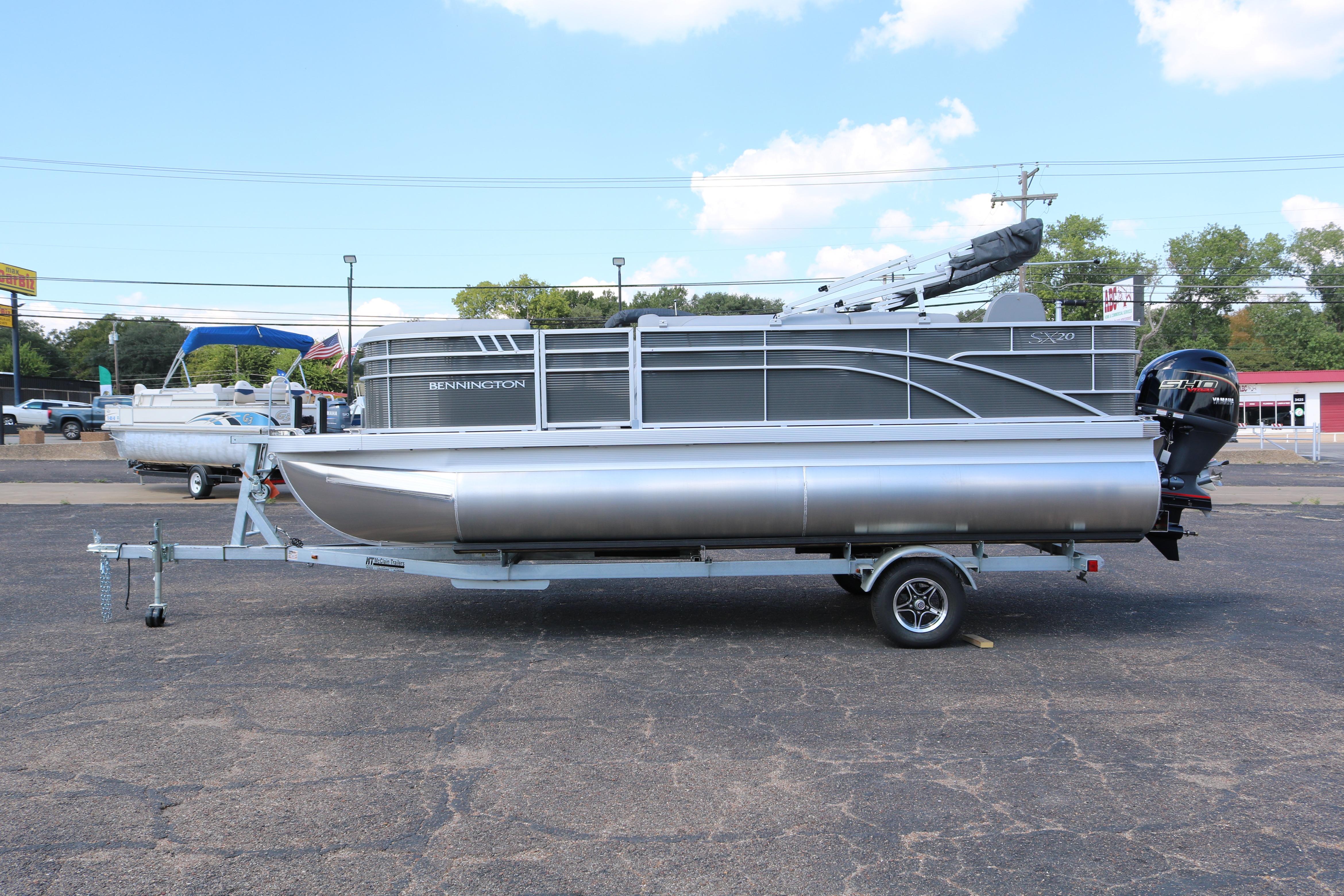2026 Bennington 20SXSNP Rear Fish pontoon boat on trailer, parked outdoors.