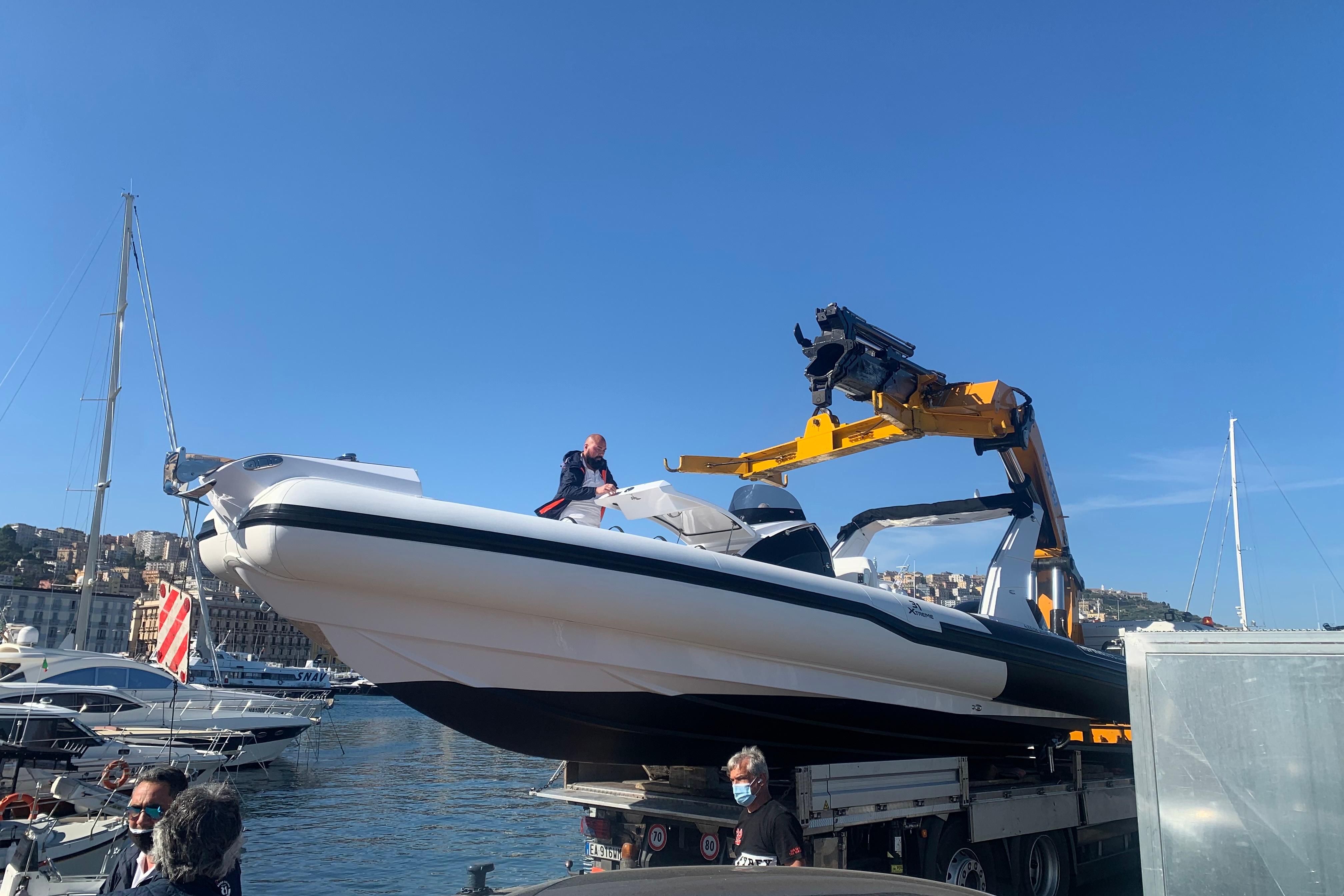 Novamares 31 Extreme 2021 boat being lifted by crane at marina.