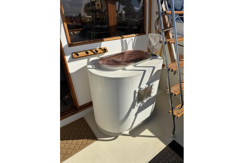 1985 Egg Harbor 33 Sedan boat deck with ladder and fishing equipment.