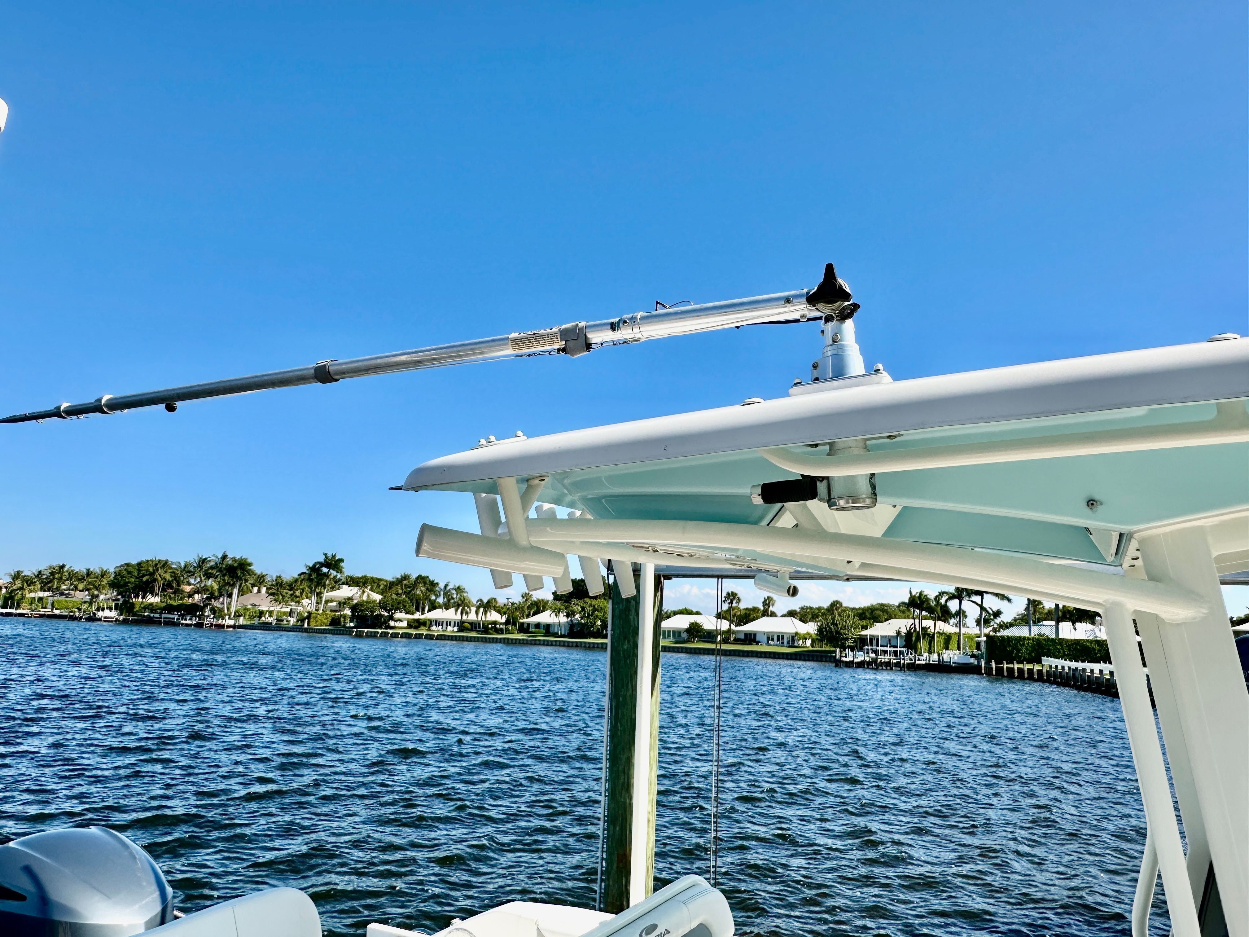 A 2022 Cobia 240 Center Console boat on the water with a blue sky in the background.