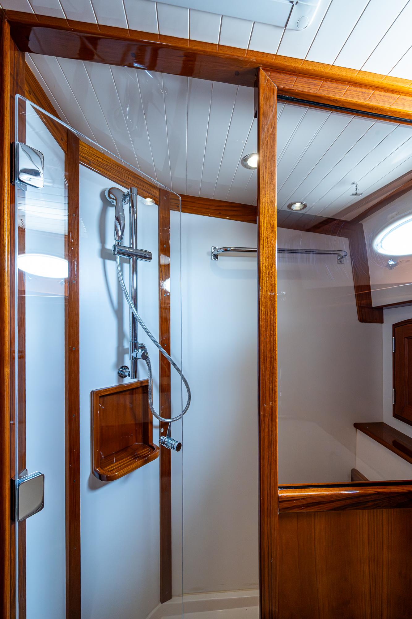 Luxurious shower in 2021 Hinckley Talaria 43 Motoryacht with wood accents and modern fixtures.