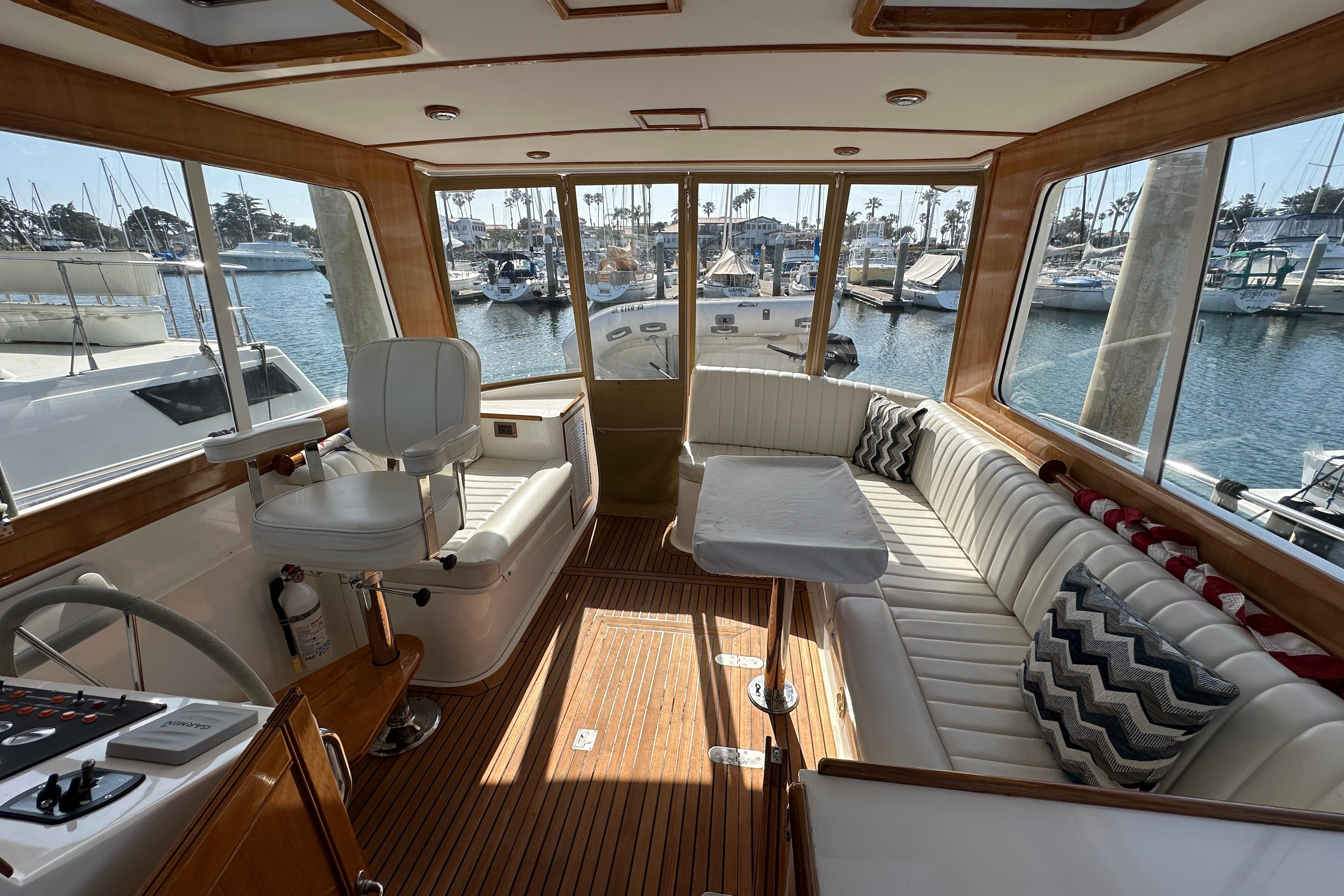 Luxurious 2003 Grand Banks 43 Eastbay HX yacht interior with plush seating and scenic marina view.