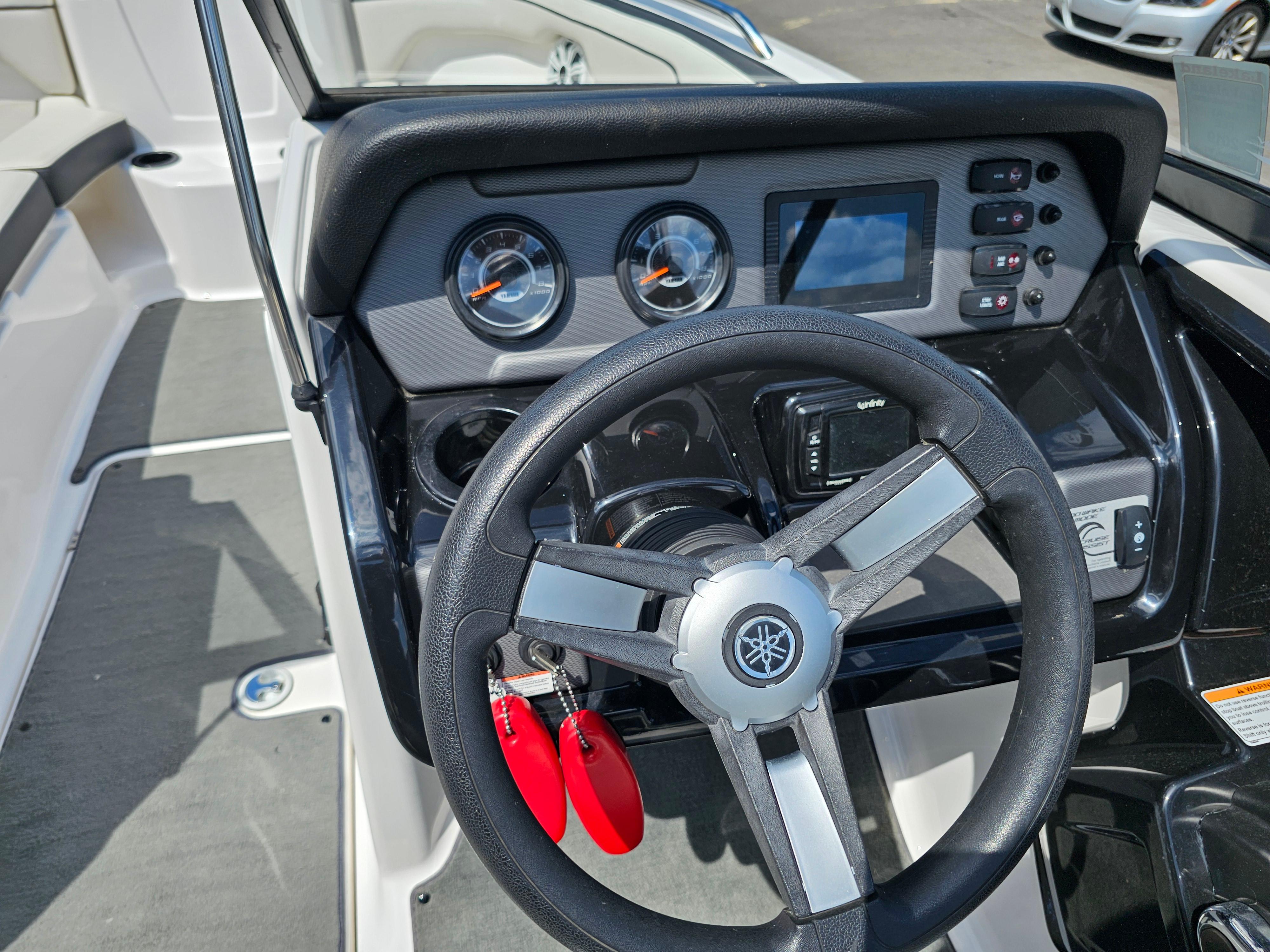 Steering wheel and dashboard of 2017 Yamaha Boats SX210, featuring gauges and controls.