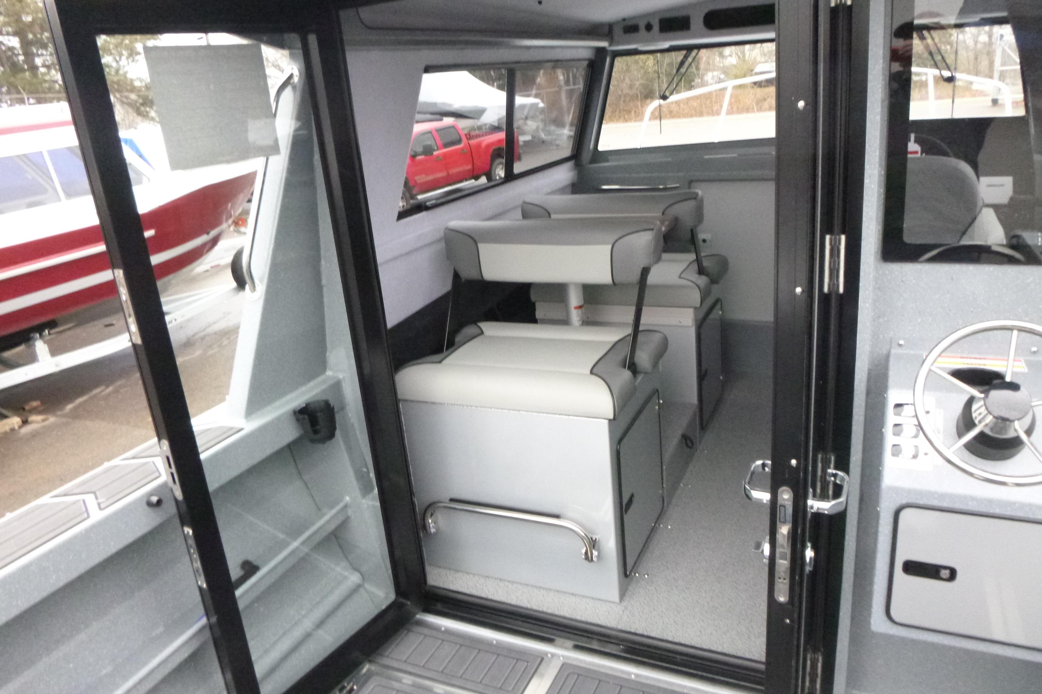 Interior of 2026 KingFisher 25 XAC boat with seating and steering wheel.