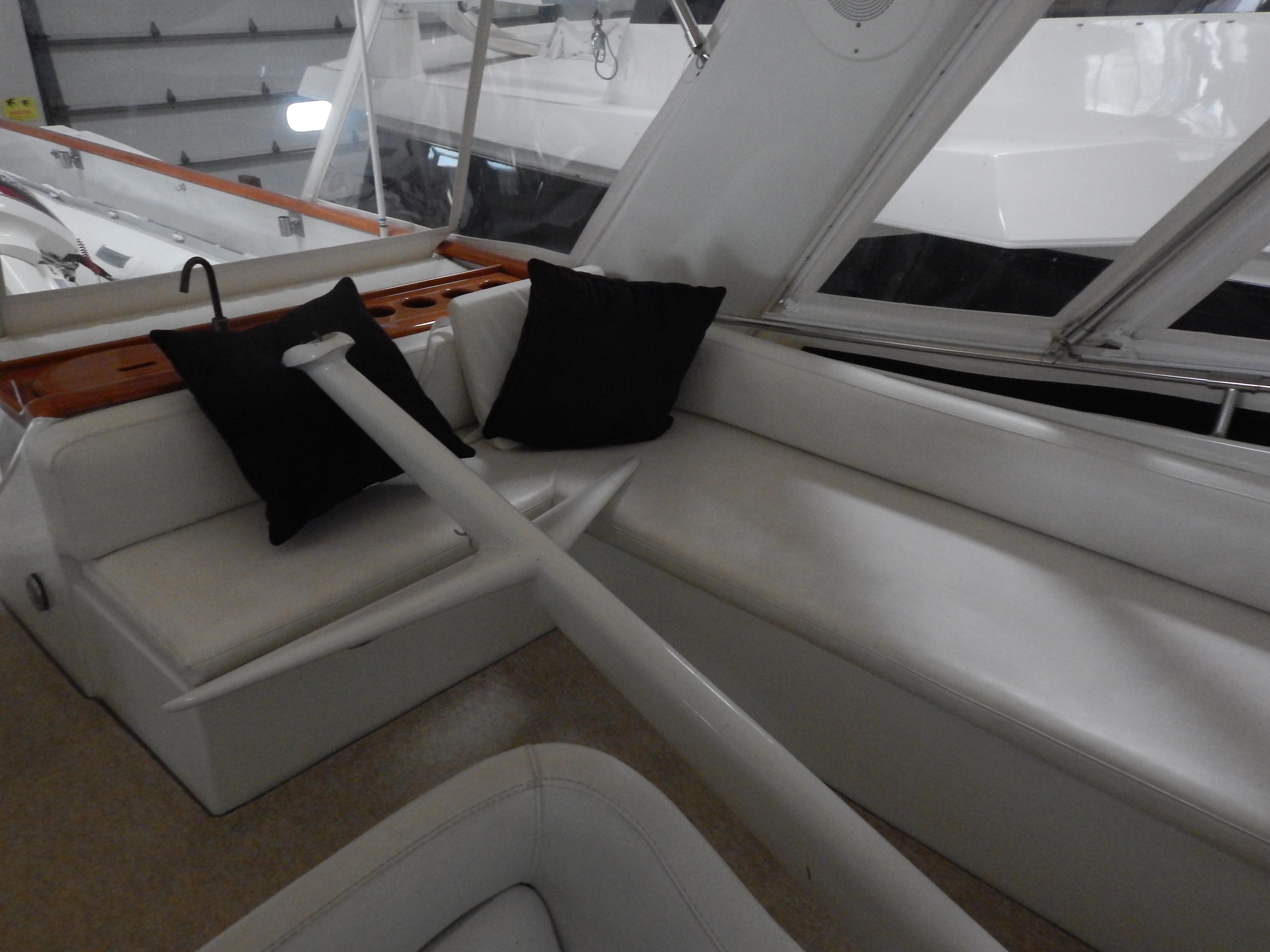1974 Pacemaker Cockpit Motoryacht interior with white seating and black cushions.