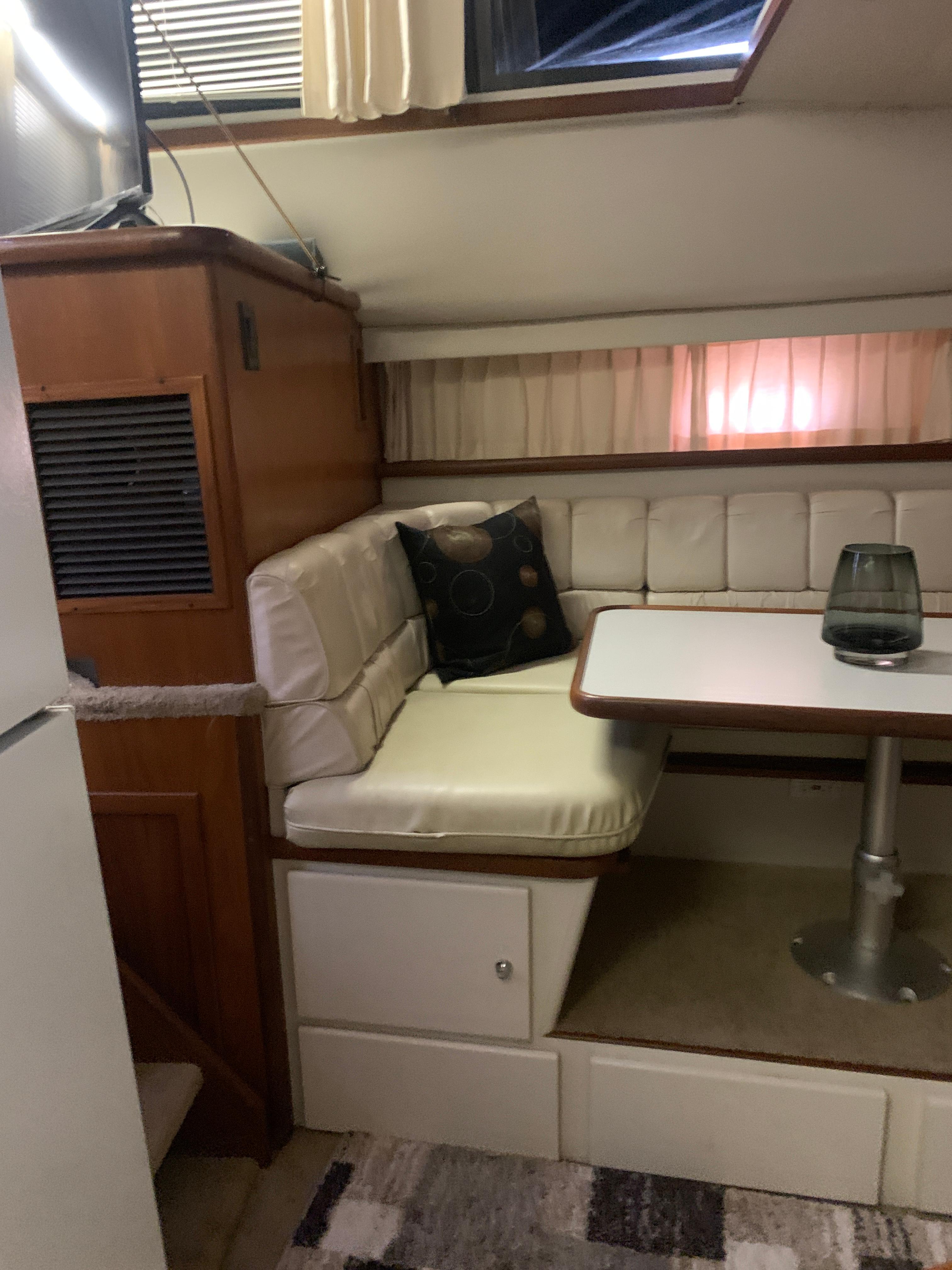 1994 Carver 440 Aft Cabin Motor Yacht interior with dining area and cushioned seating.