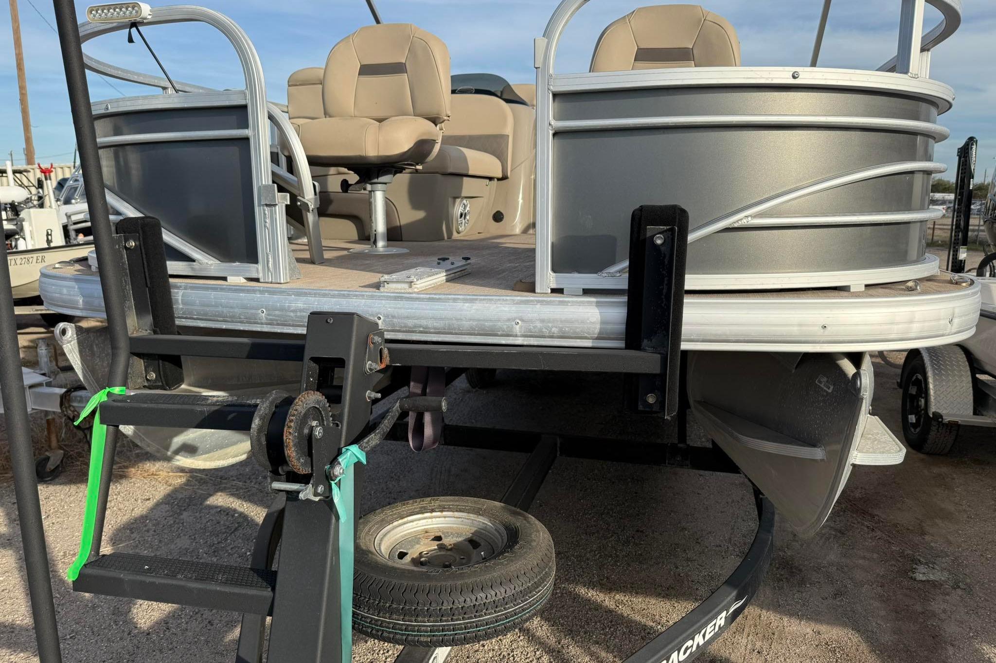 2023 Sun Tracker Fishin' Barge 22 DLX pontoon boat on trailer, close-up view.