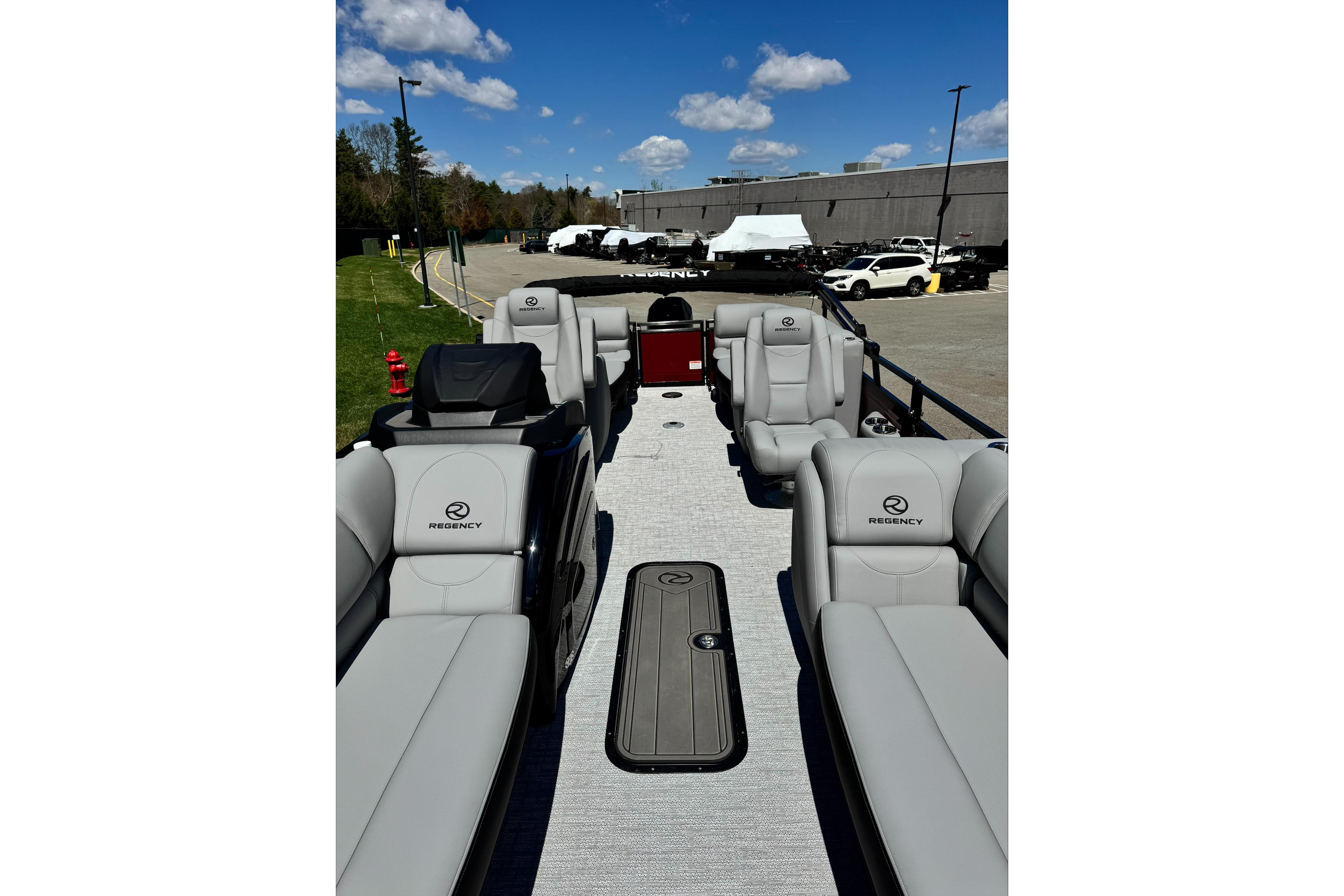 2026 Regency 230 DL pontoon boat with luxurious seating and sleek design under a clear blue sky.