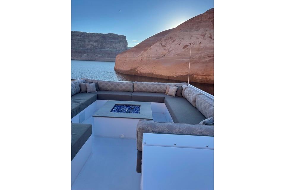 Luxurious seating area on Adonia's 2021 "The Queen Elizabeth" yacht, with scenic canyon view.